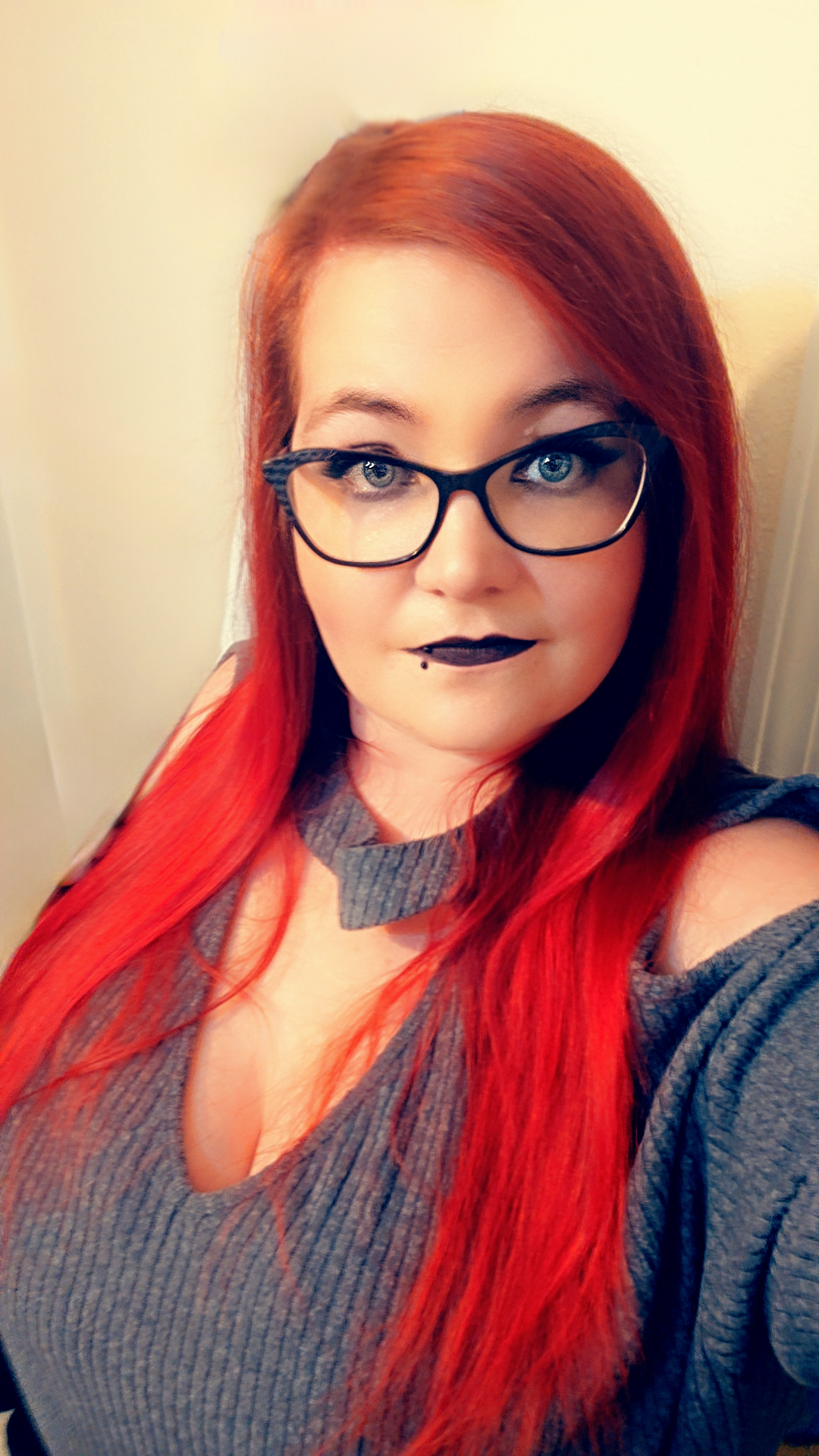 Portrait of business owner. Woman with long red hair and glasses.