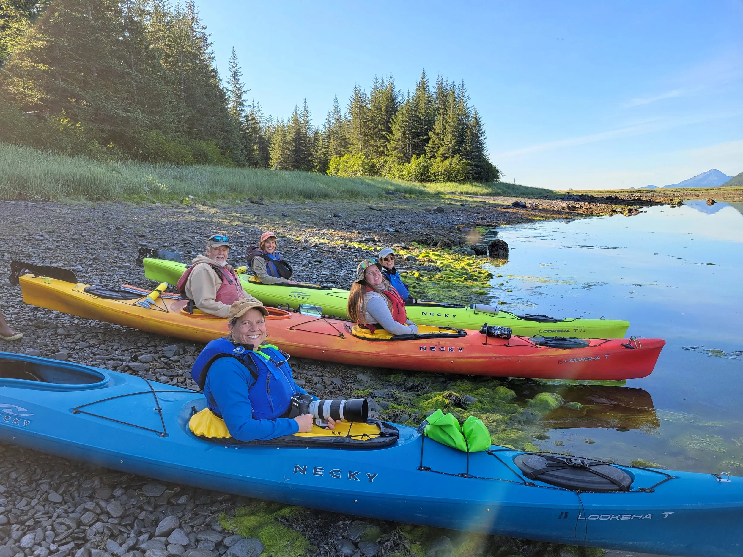 Kayakers preparing to launch from the shoreline of Pedersen Lagoon during an excursion to Addison Lake in Kenai Fjords National Park, Alaska.