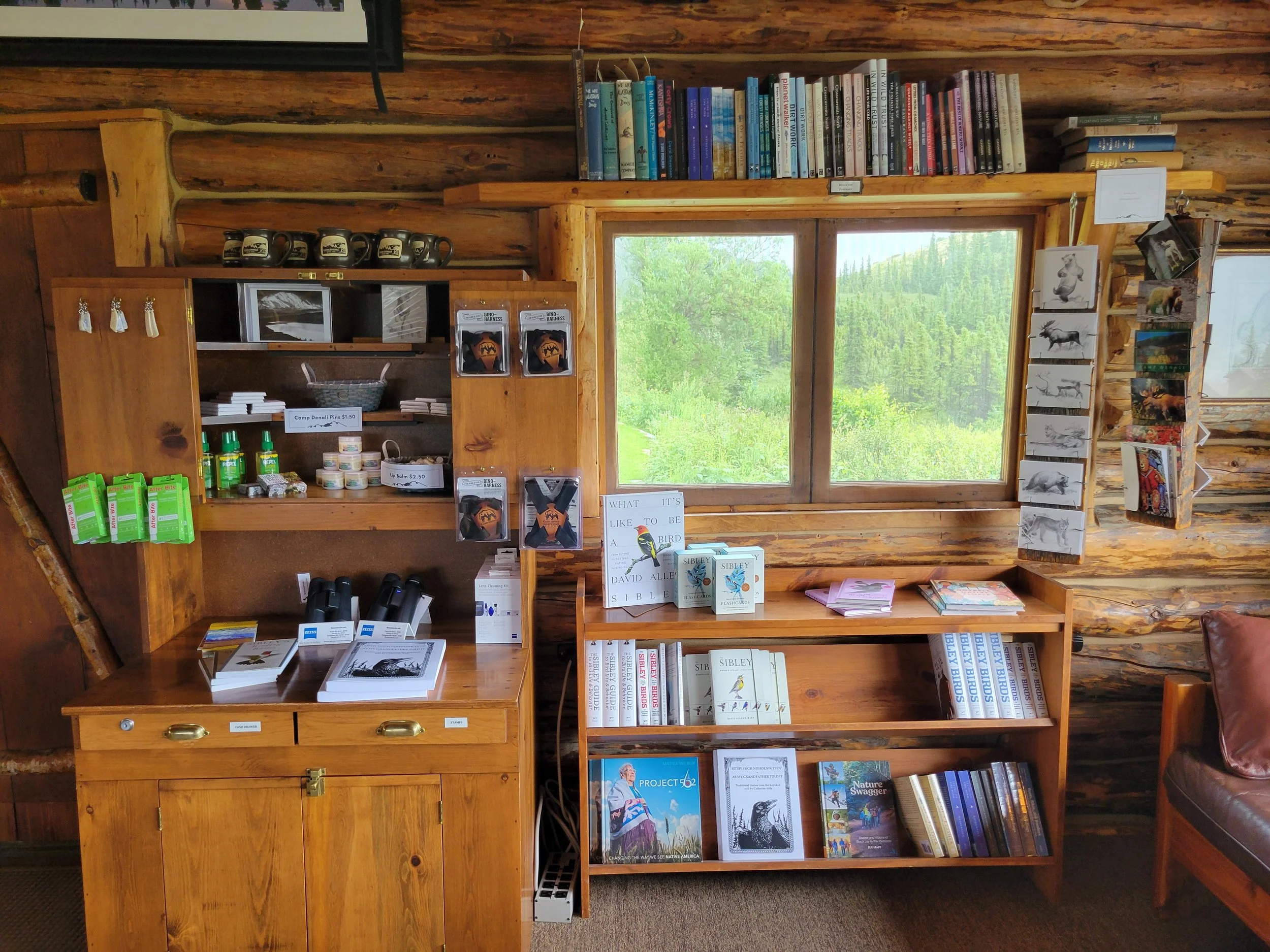 Bookshelves filled with field guides and natural history books inside the Camp Denali lodge.