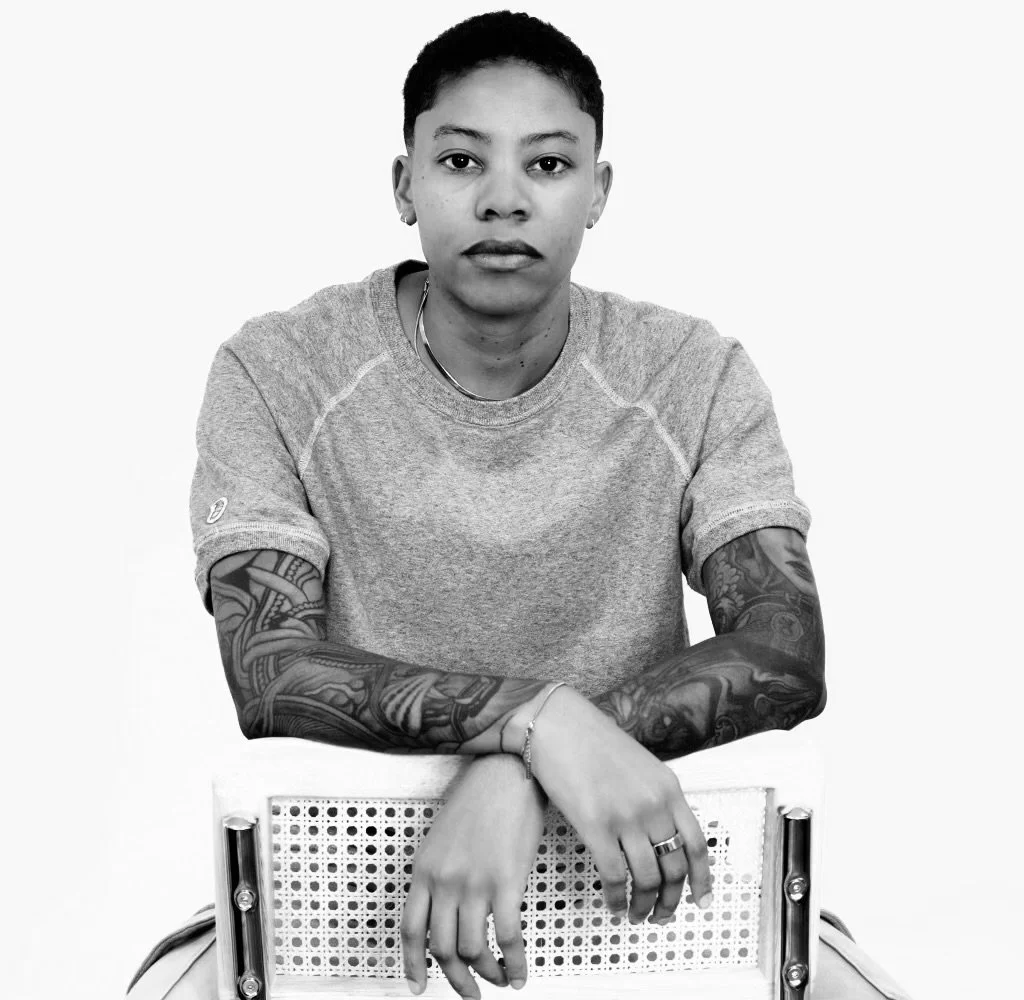 black and white photo of Julia sitting on one of her barstools, head on