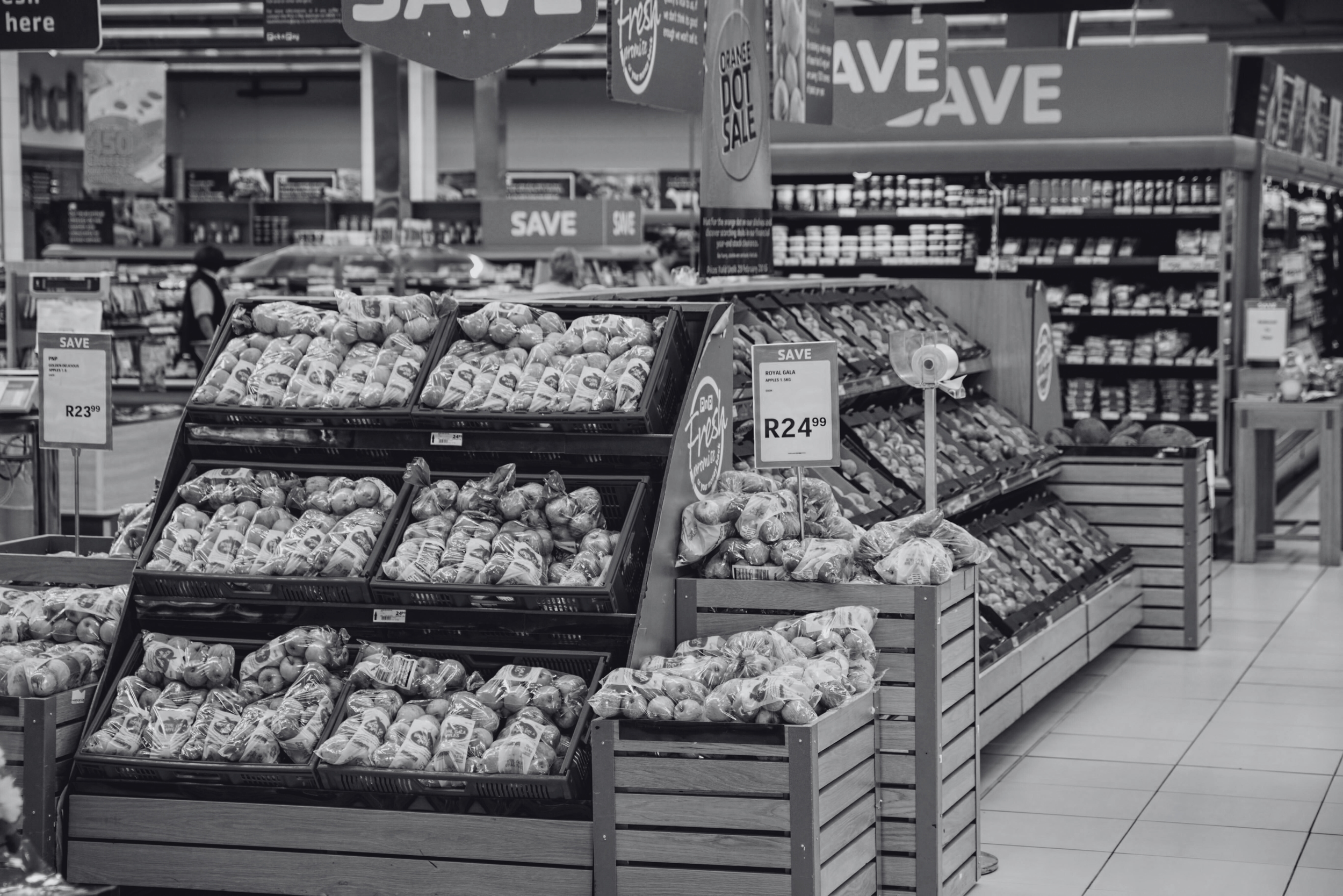 Grocery store produce section with potatoes on display and bright signage indicating discounts.