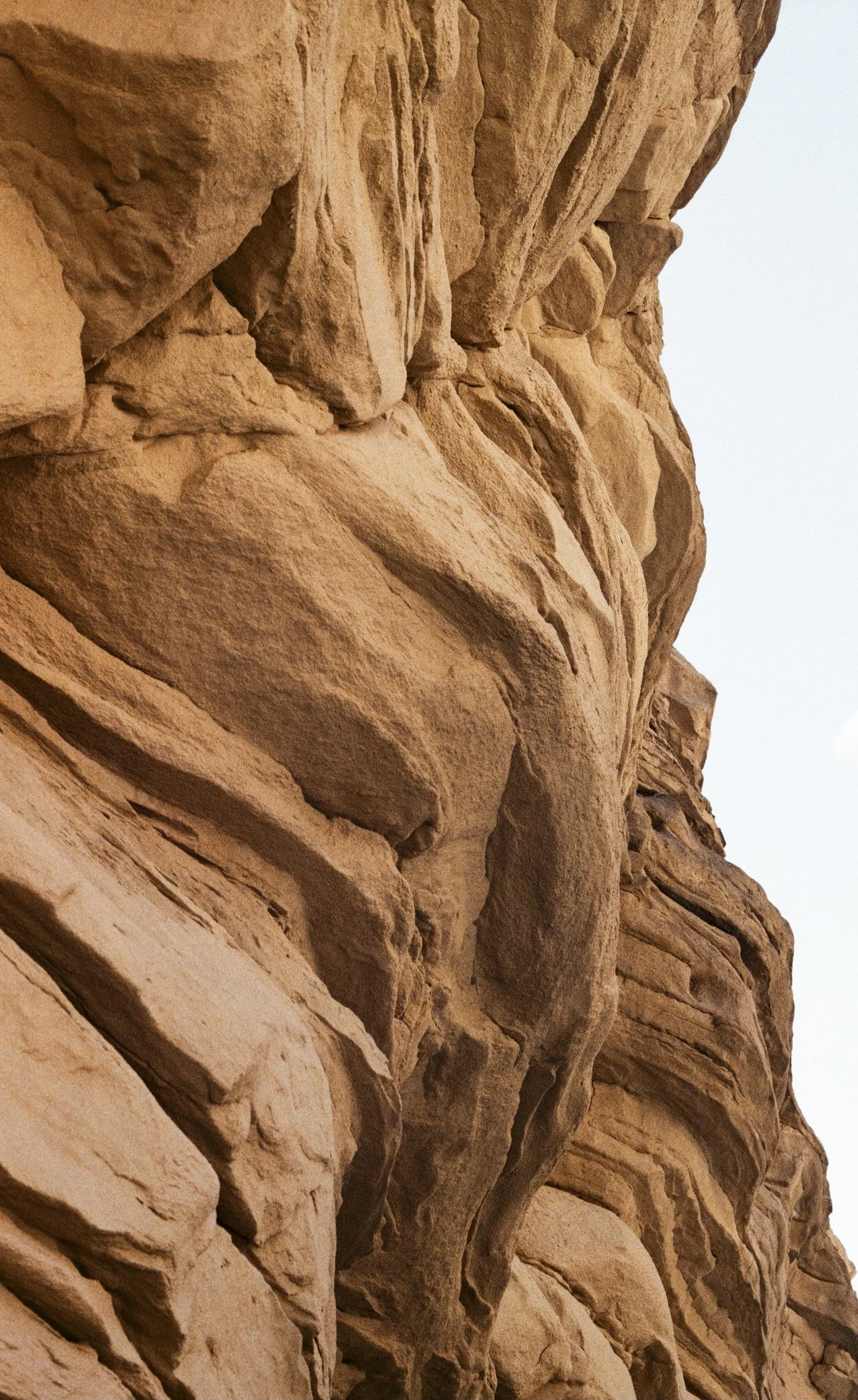 Close-up of layered sandstone rock formation with rough texture and natural color variation.