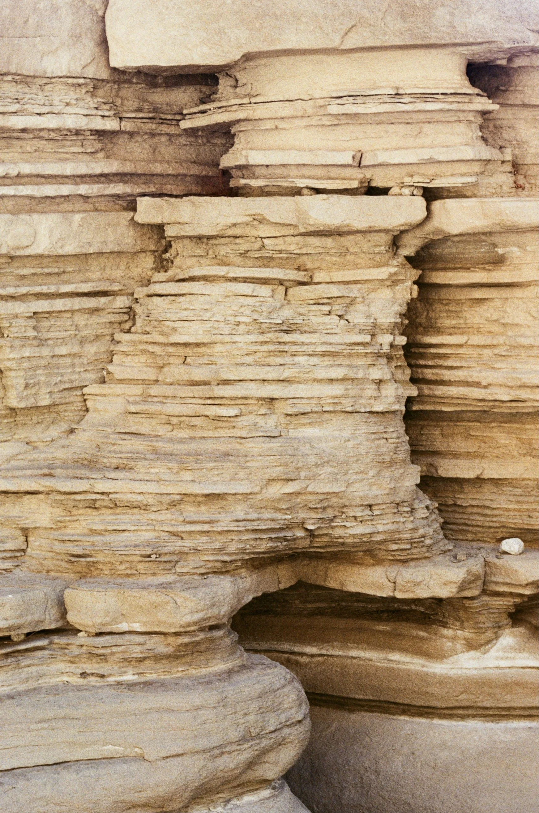 Close-up of layered sedimentary rock formations with horizontal strata in beige and tan colors.