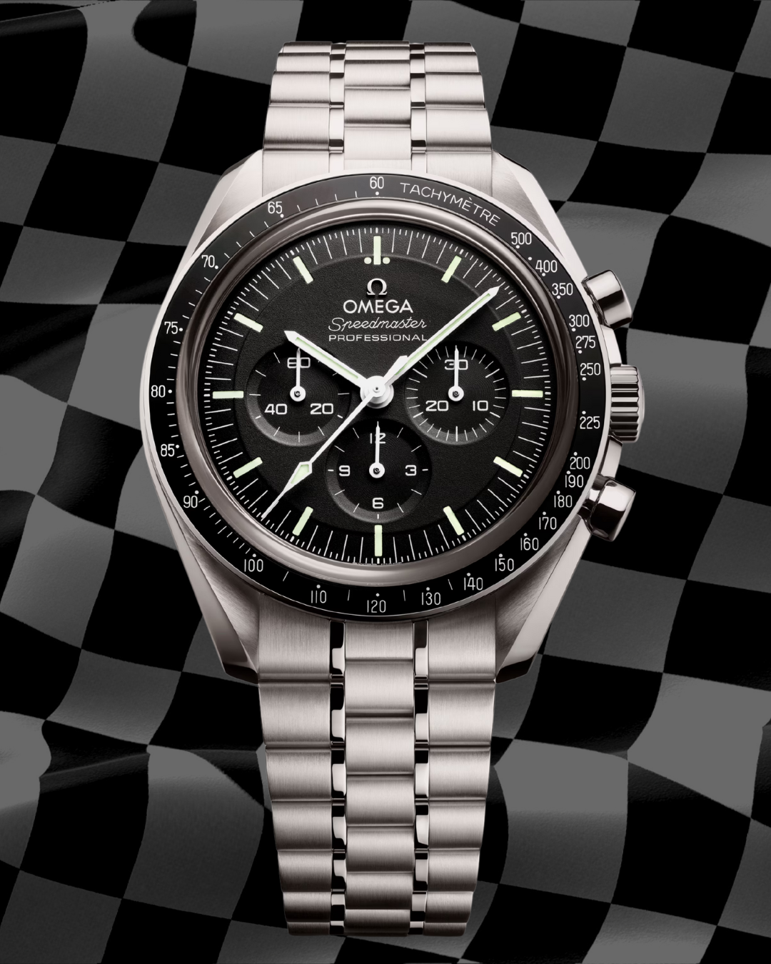 A silver Omega Speedmaster Professional watch with a black dial and chronograph features, resting on a checkered background.