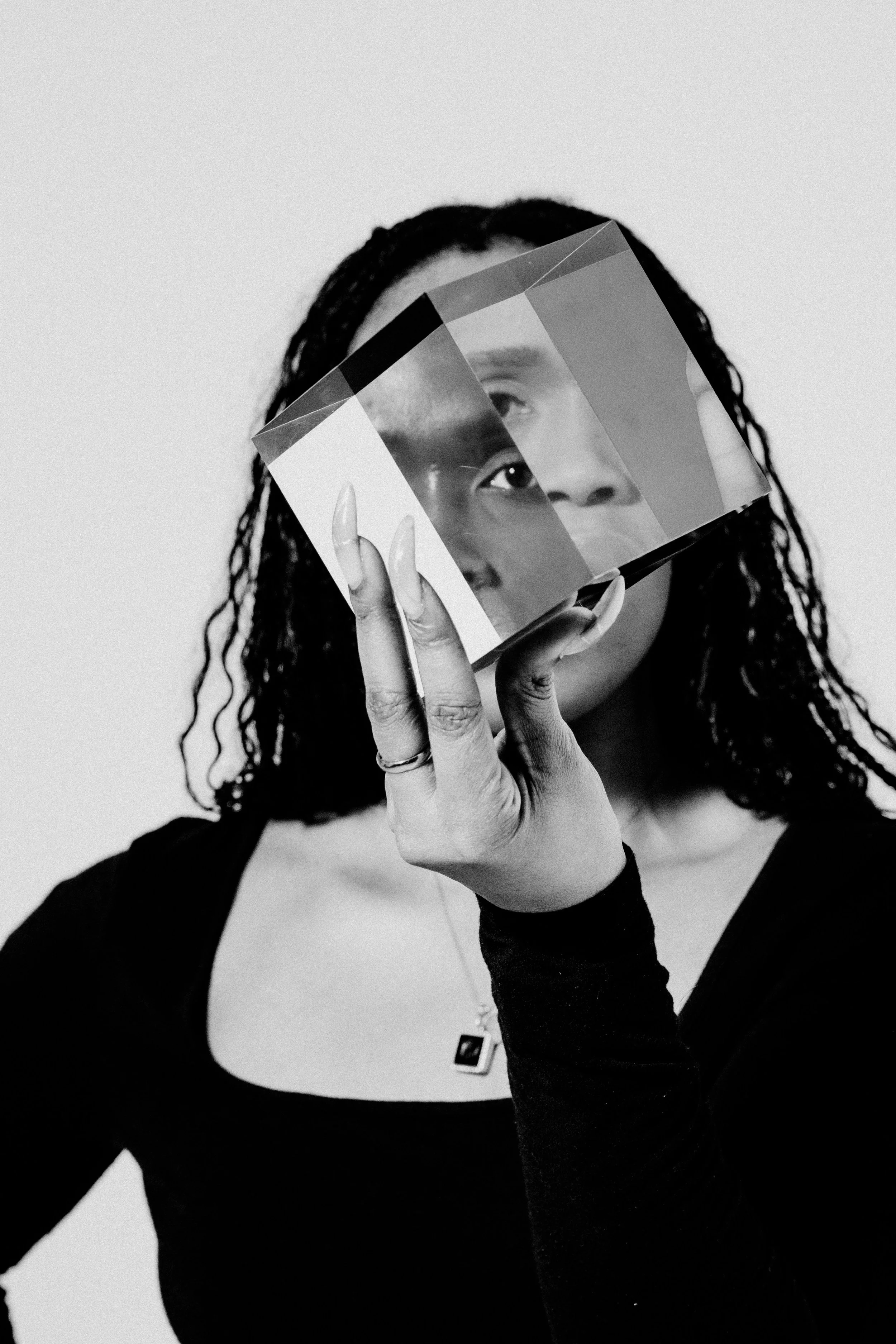 A woman holds a prism up to her eye, to symbolize perspective.