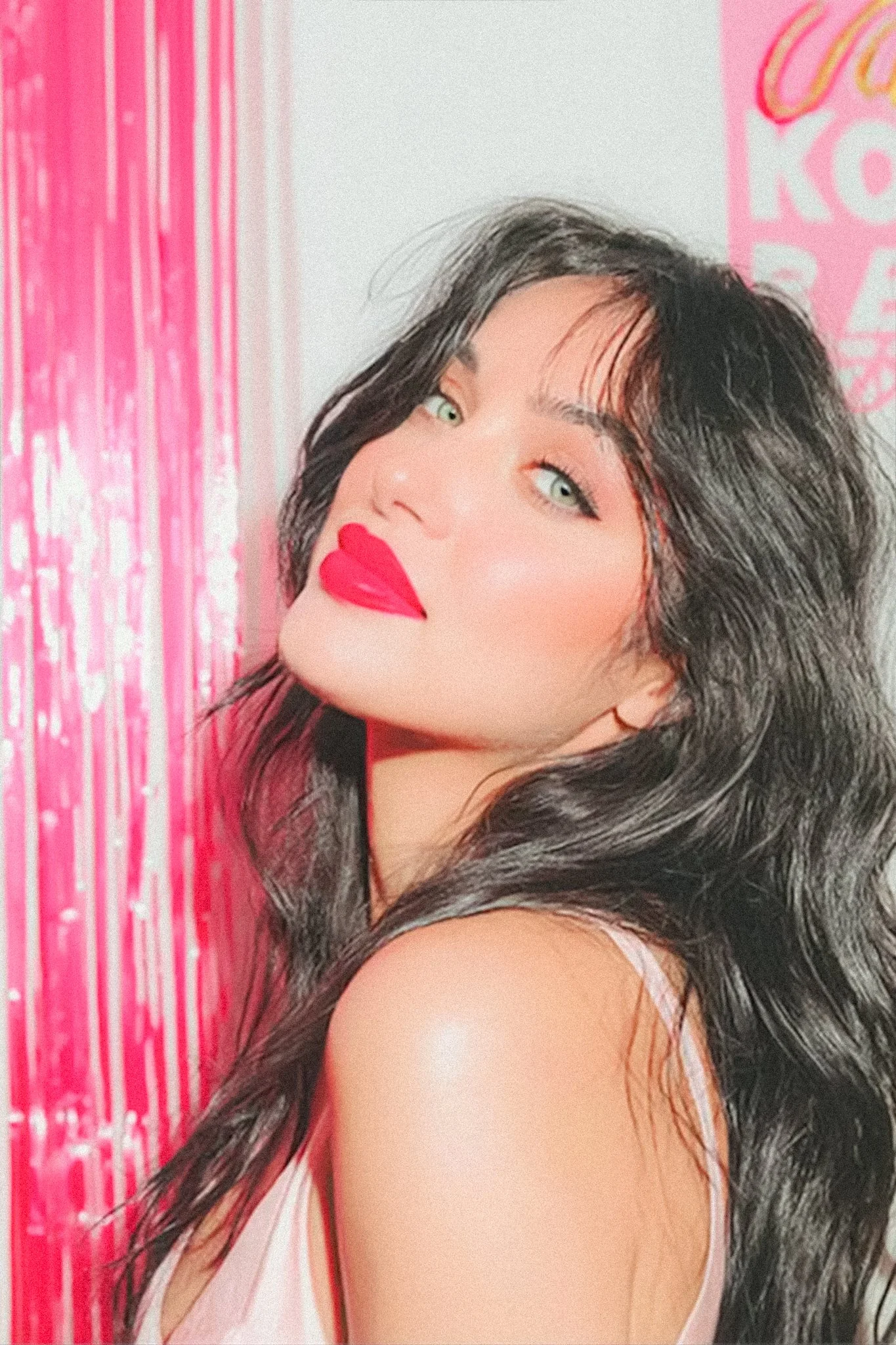 Editorial style image of a woman turning her head, red lips and dark waves, used as eye-catching branding photography for social media.