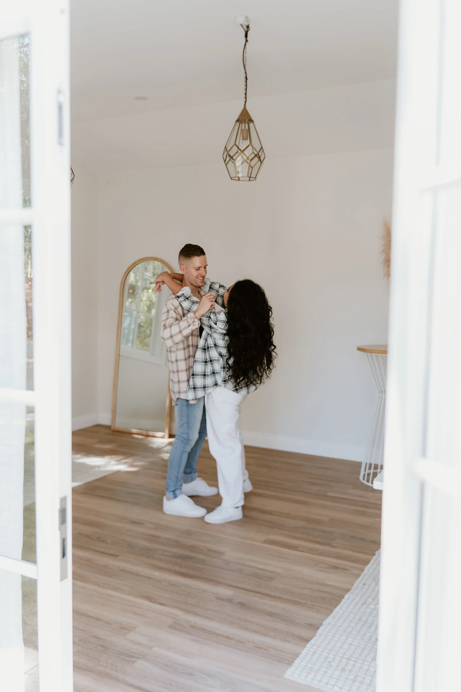 Candid couple moment in a light and bright room, capturing their movement, joy, and affection