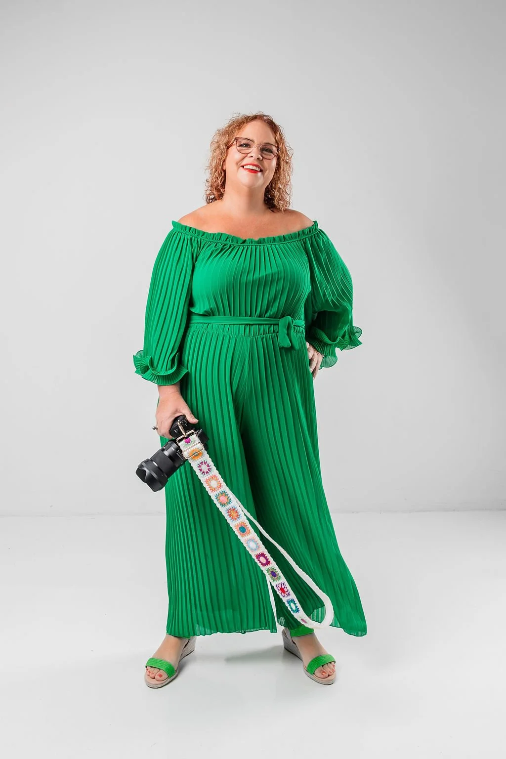 A portrait of Perth Wedding and Family photographer, Danielle Elizabeth, smiling brightly with her camera in hand