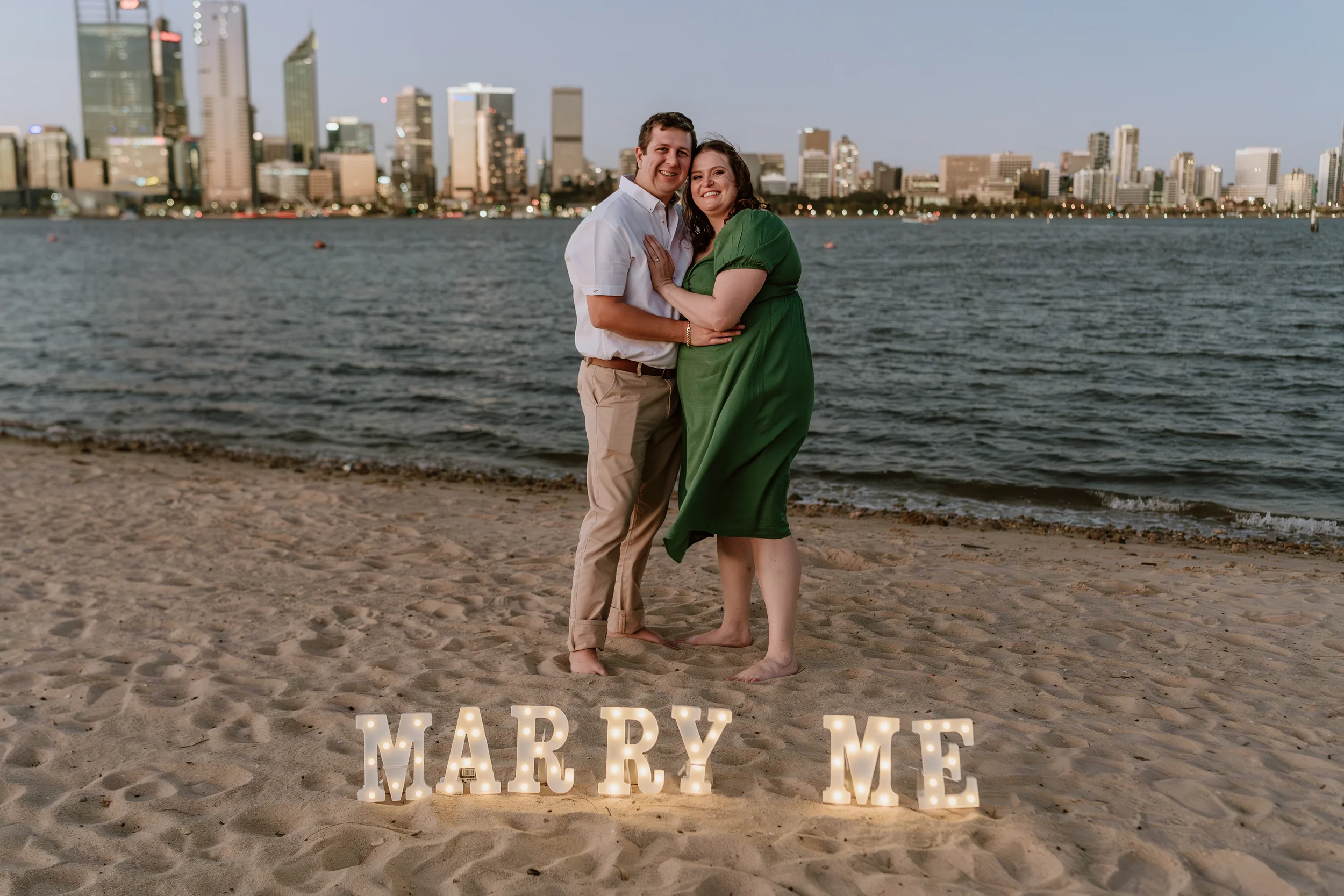 Romantic portrait with warm sunset colours and the glowing 'Marry Me' lights on the South Perth Foreshore