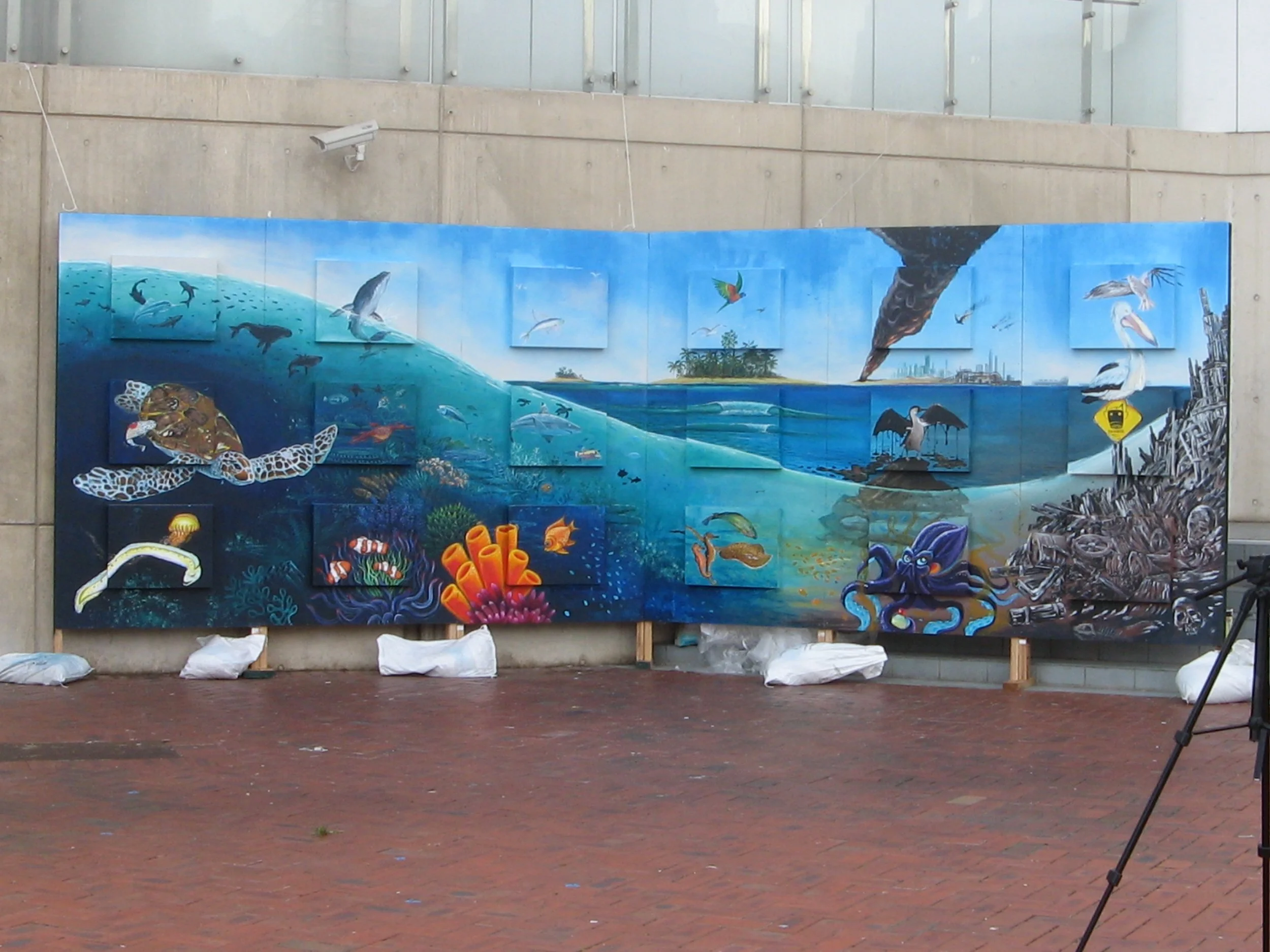 Underwater scene with marine life, coral, and a submerged cityscape, depicting pollution and environmental issues.