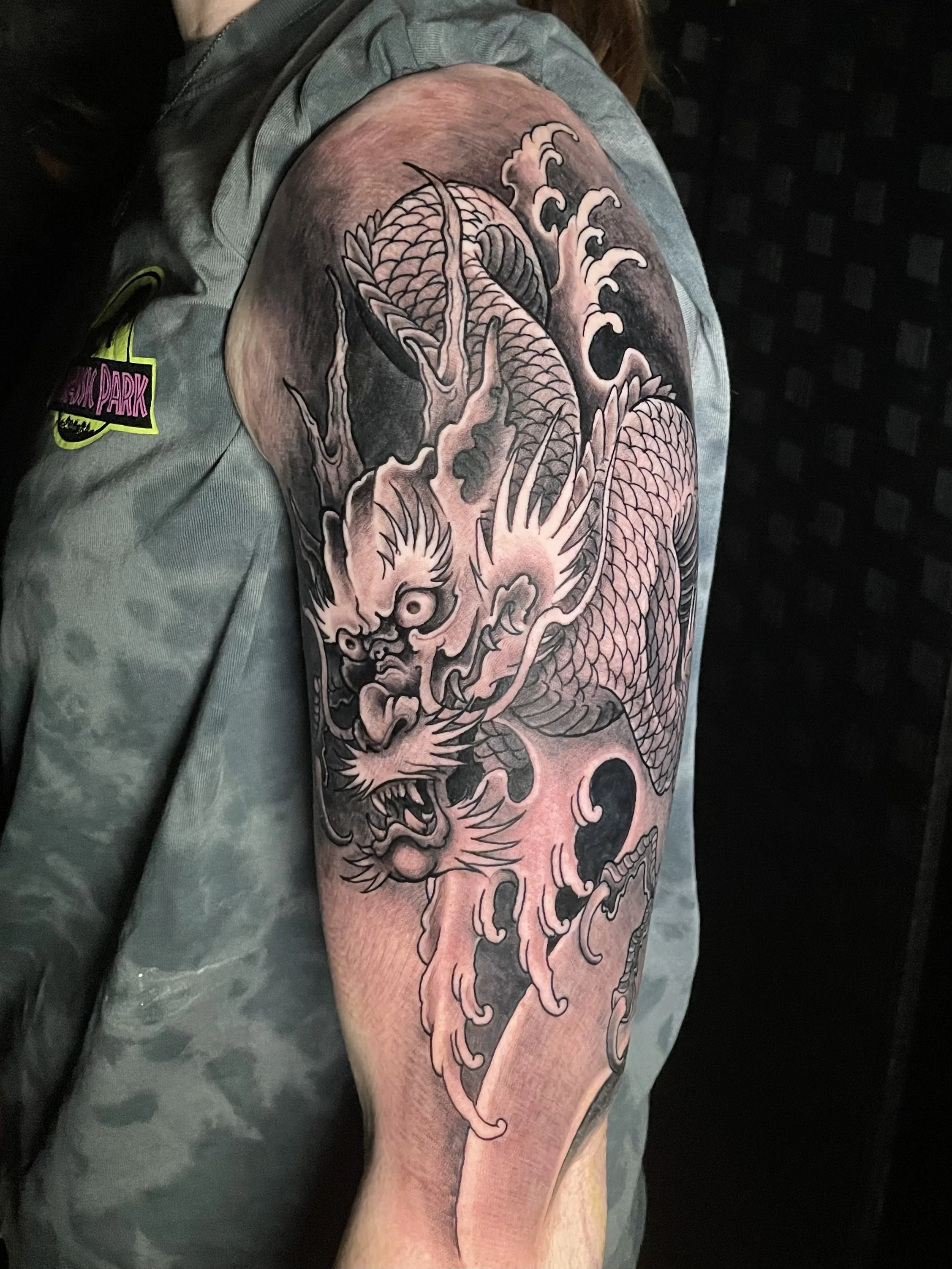Tatuaje de un dragón en el brazo de una persona.