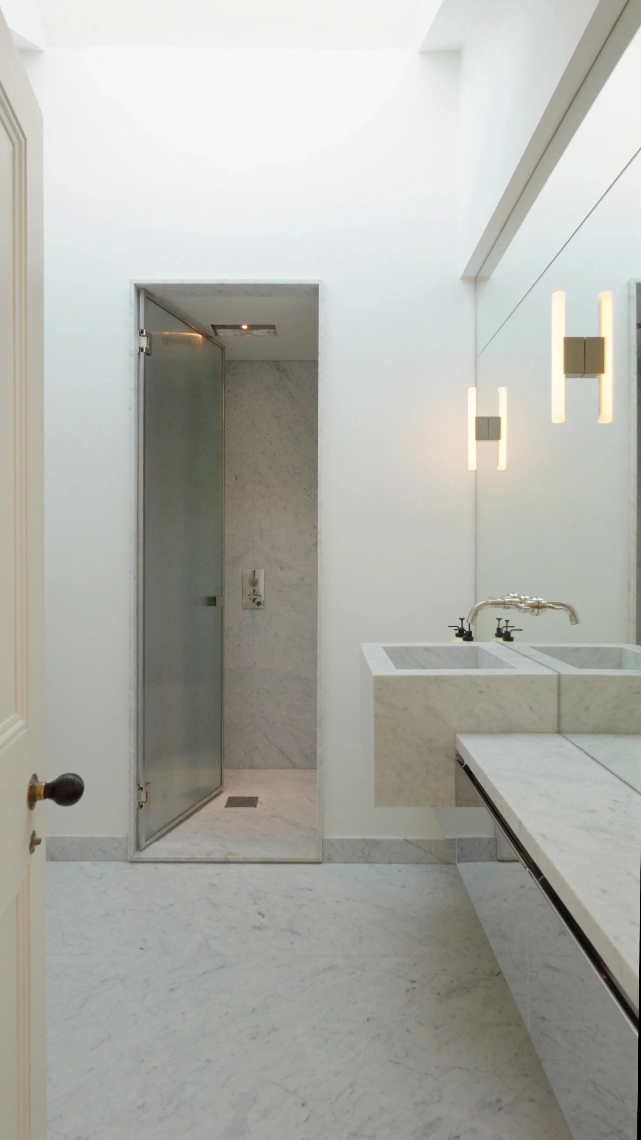 Modern bathroom with marble countertops and a glass shower enclosure