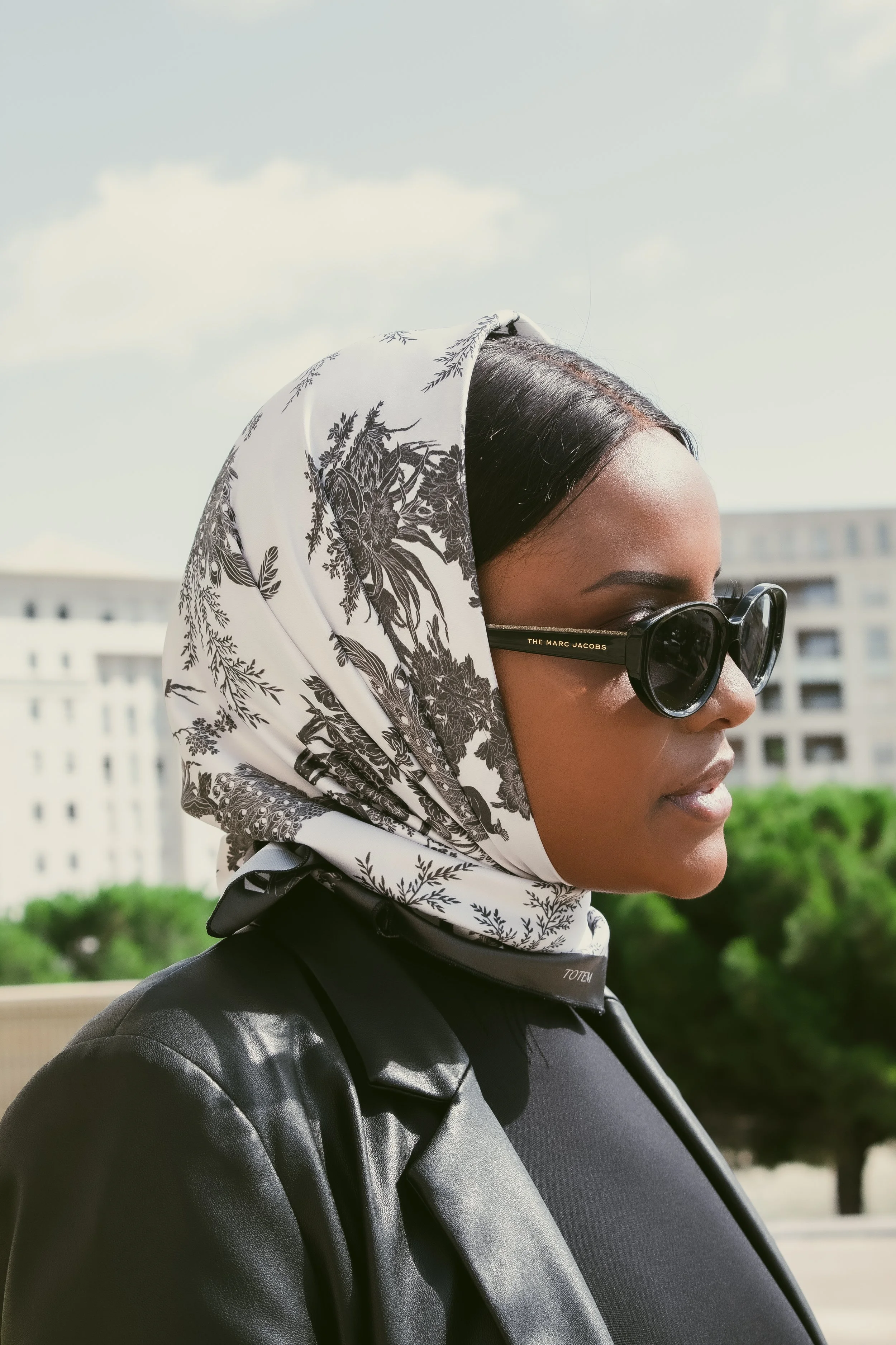 A black and white floral pattern featuring elegant peacocks, blooming flowers, and leafy branches.