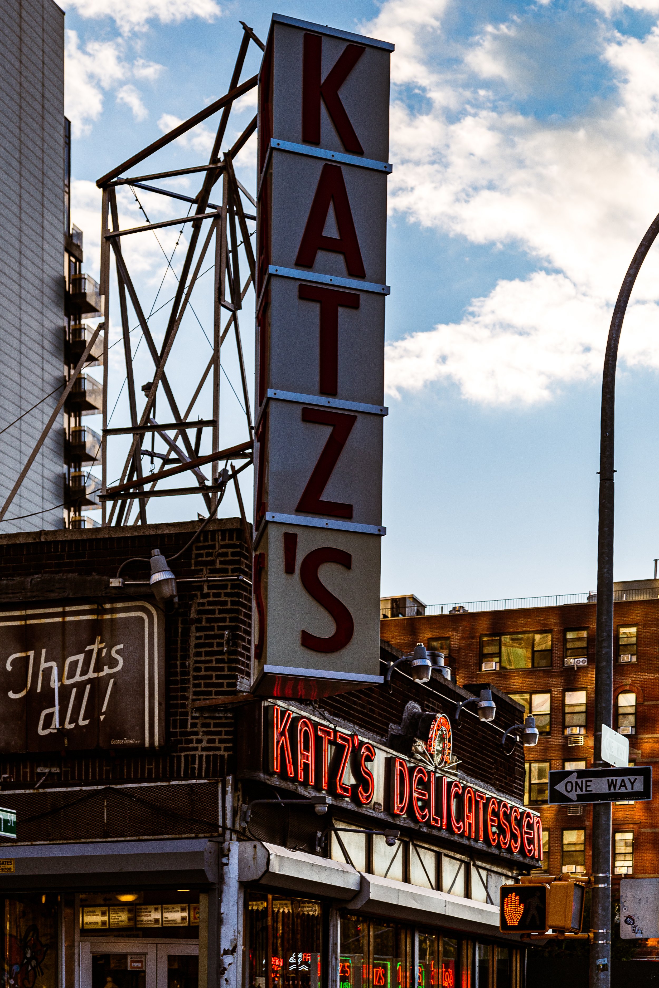 Vertical neon sign spelling 'KATZ'S' above a storefront with a sign reading 'KATZ'S DELICATESSEN'.