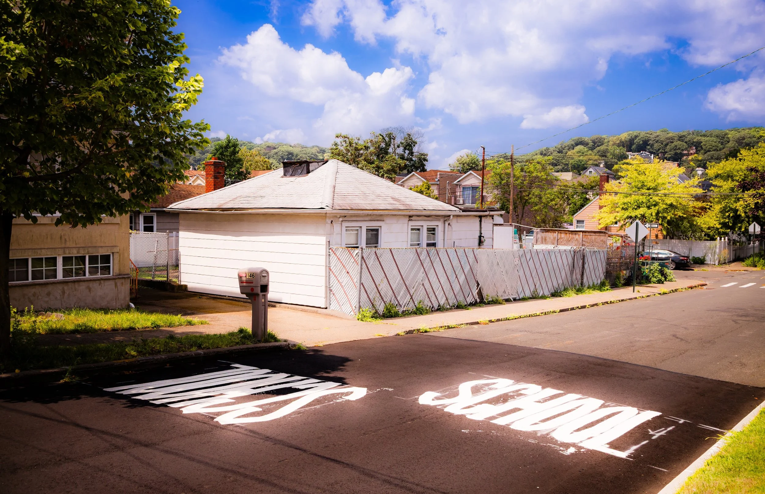 A residential street scene with a stop sign and a large