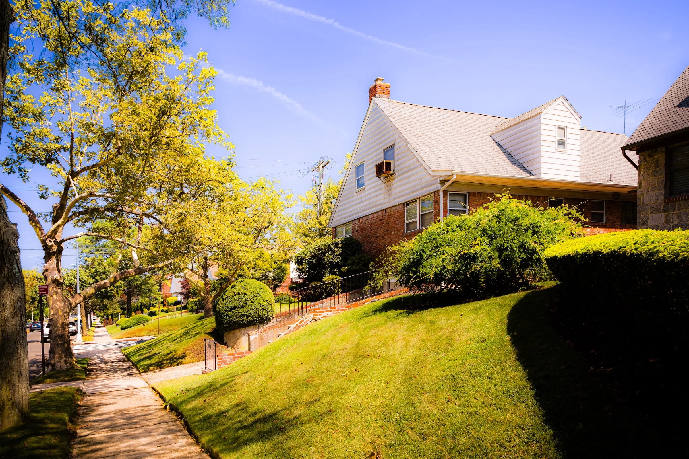 Street sign for Hollis Hills and 215th Street, mounted on a wooden pole.