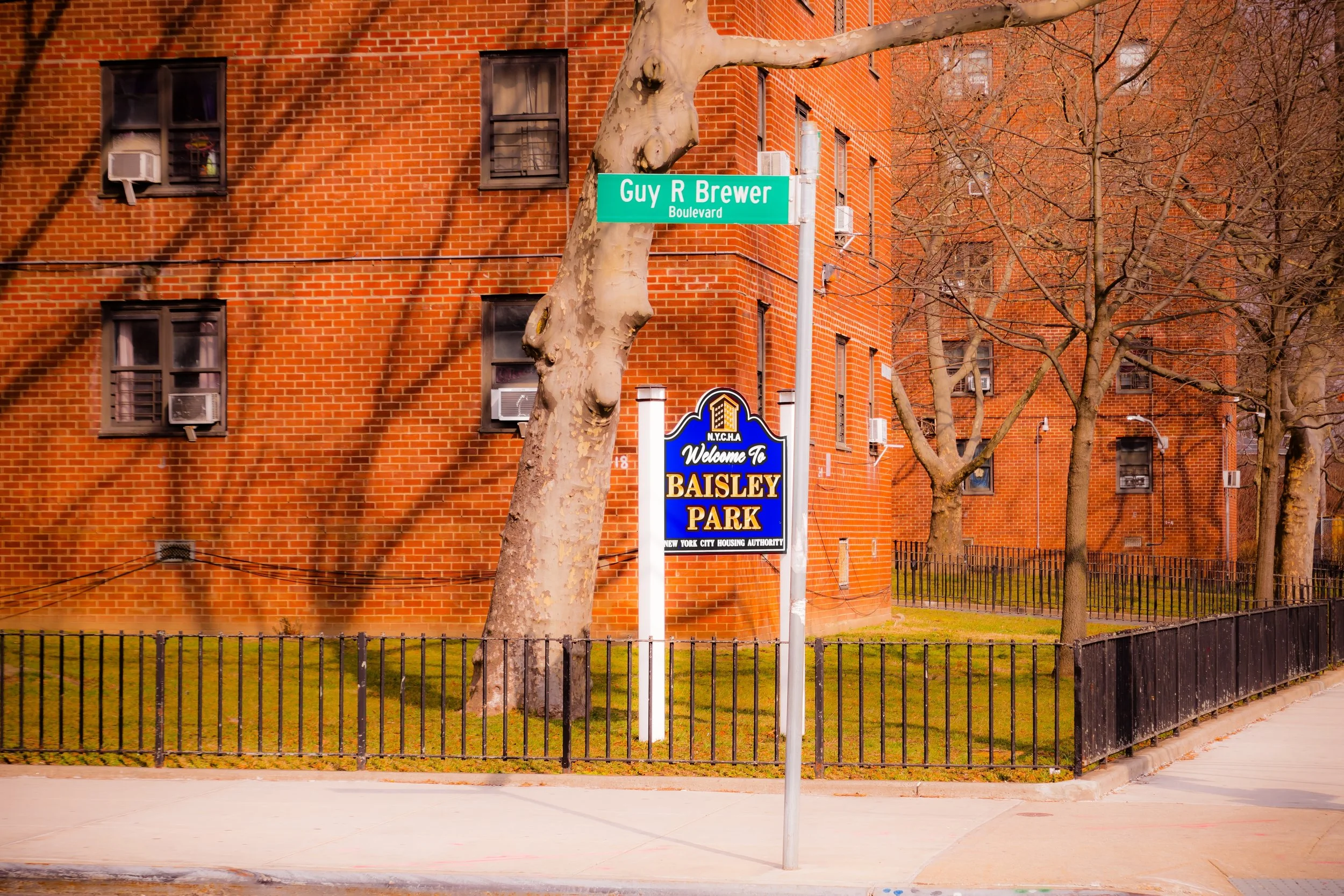 Street sign at Guy R. Brewer Boulevard and a welcome sign for Baisley Park in New York City.