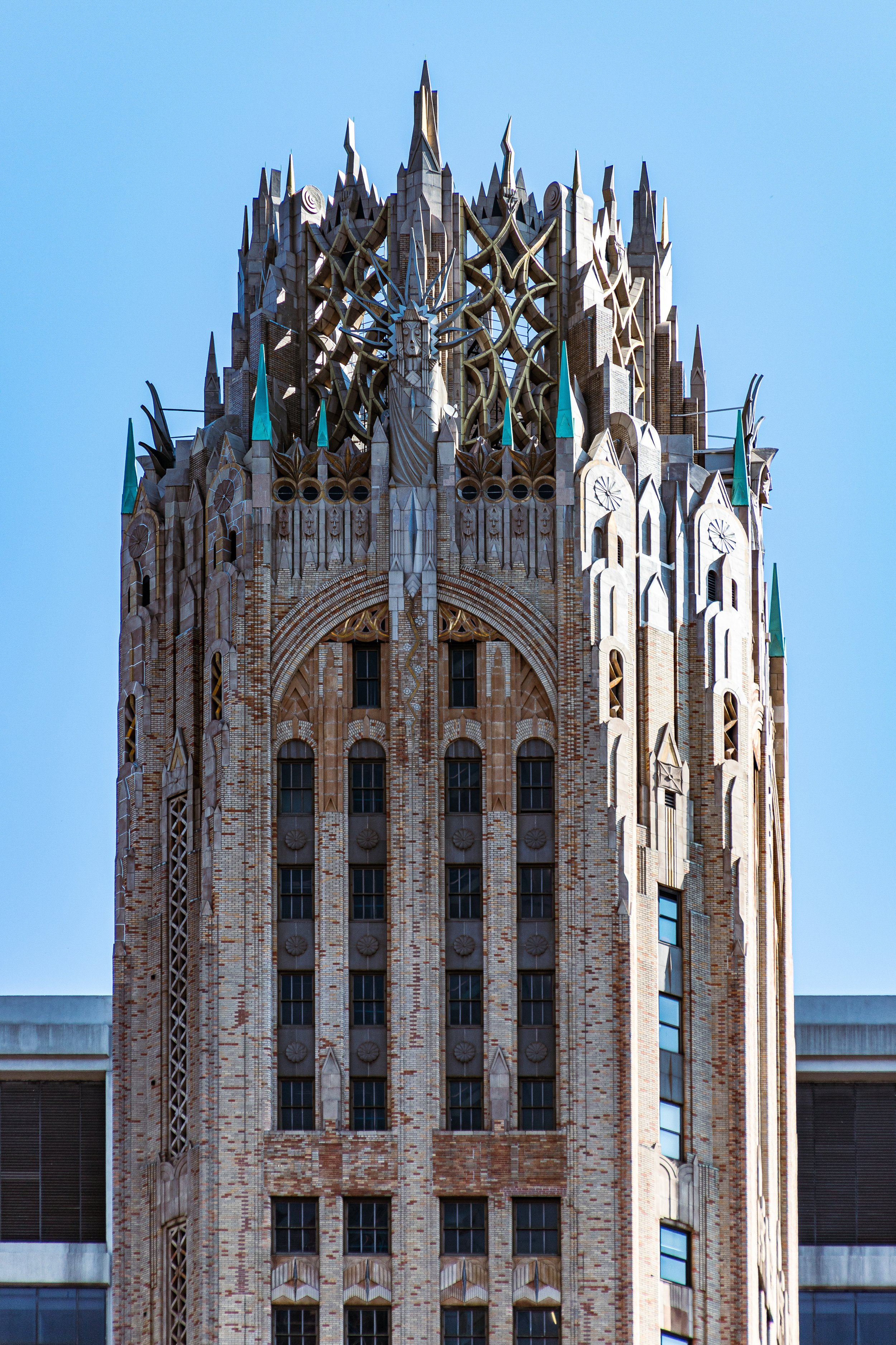 A tall, ornate building with detailed architecture and spires against a clear blue sky.