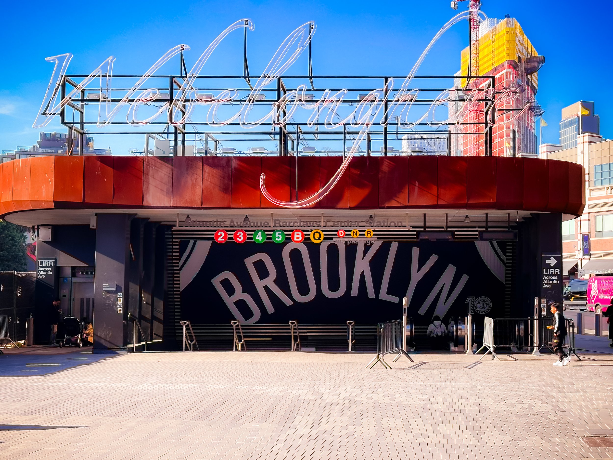 Exterior of the Brooklyn subway entrance with large sign spelling 'Brooklyn' and colorful buildings in the background.