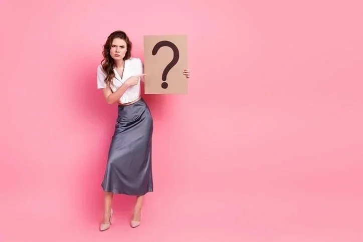 Woman holding a question mark symbolising uncertainty in a new role