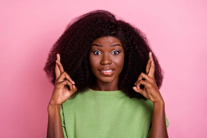 Woman crossing her fingers symbolising relying on luck in a new leadership role