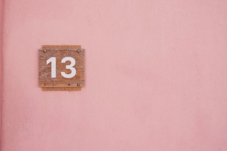 Minimalist image featuring the number 13 symbolising silence, restraint and Taylor Swift inspired leadership strategy.