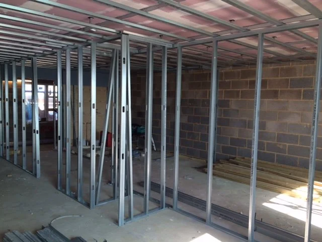 Framing of interior walls under construction with metal studs in a building site.