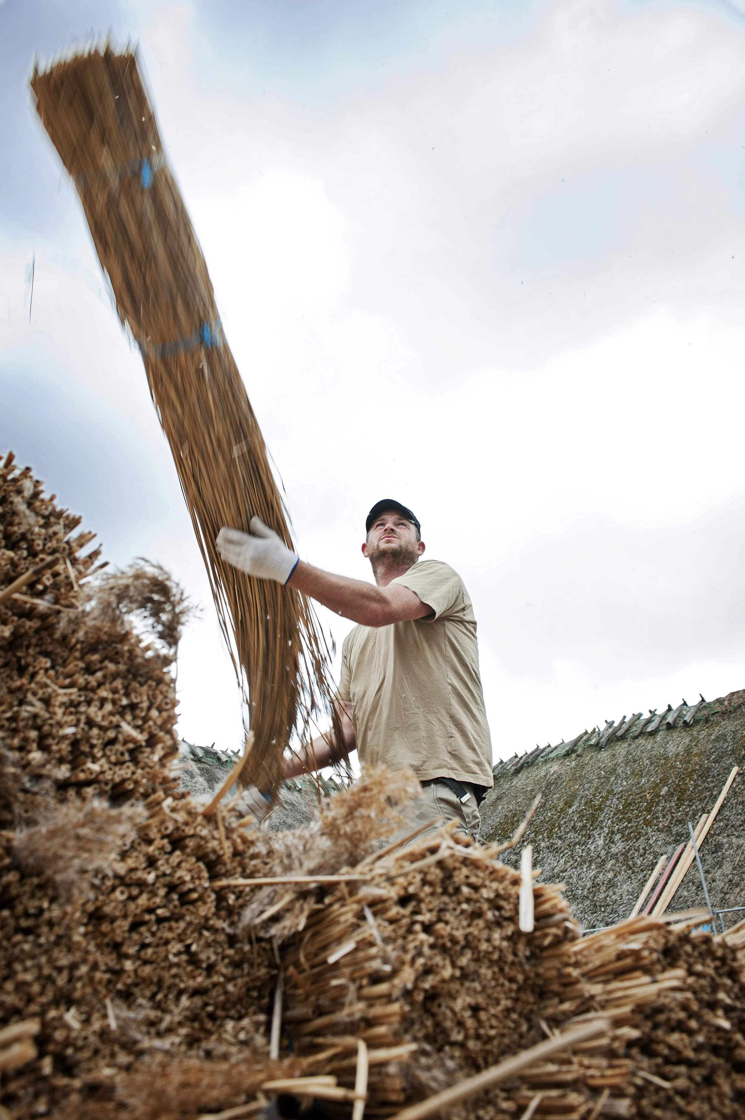 Et billede af Thomas der kaster et bundt tagrør.