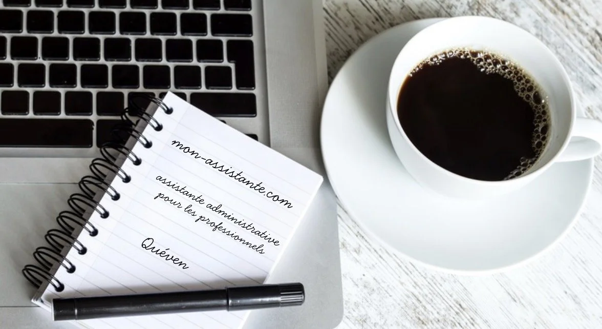 Tasse de café noir à côté d'un ordinateur portable, d'un carnet à spirale avec une inscription, et d'un stylo sur une surface en bois