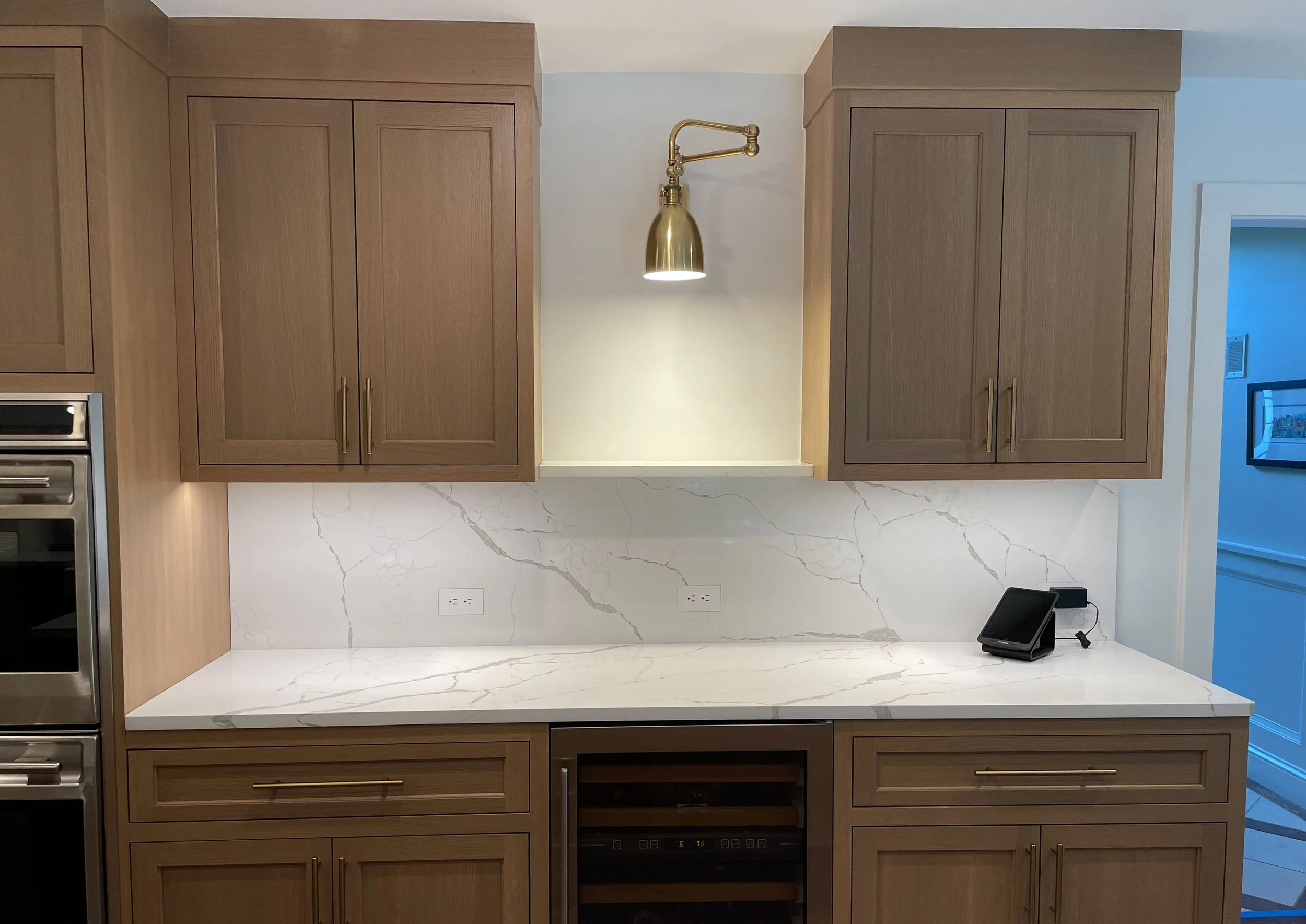 Inset white oak kitchen with quartz countertops and brass hardware 