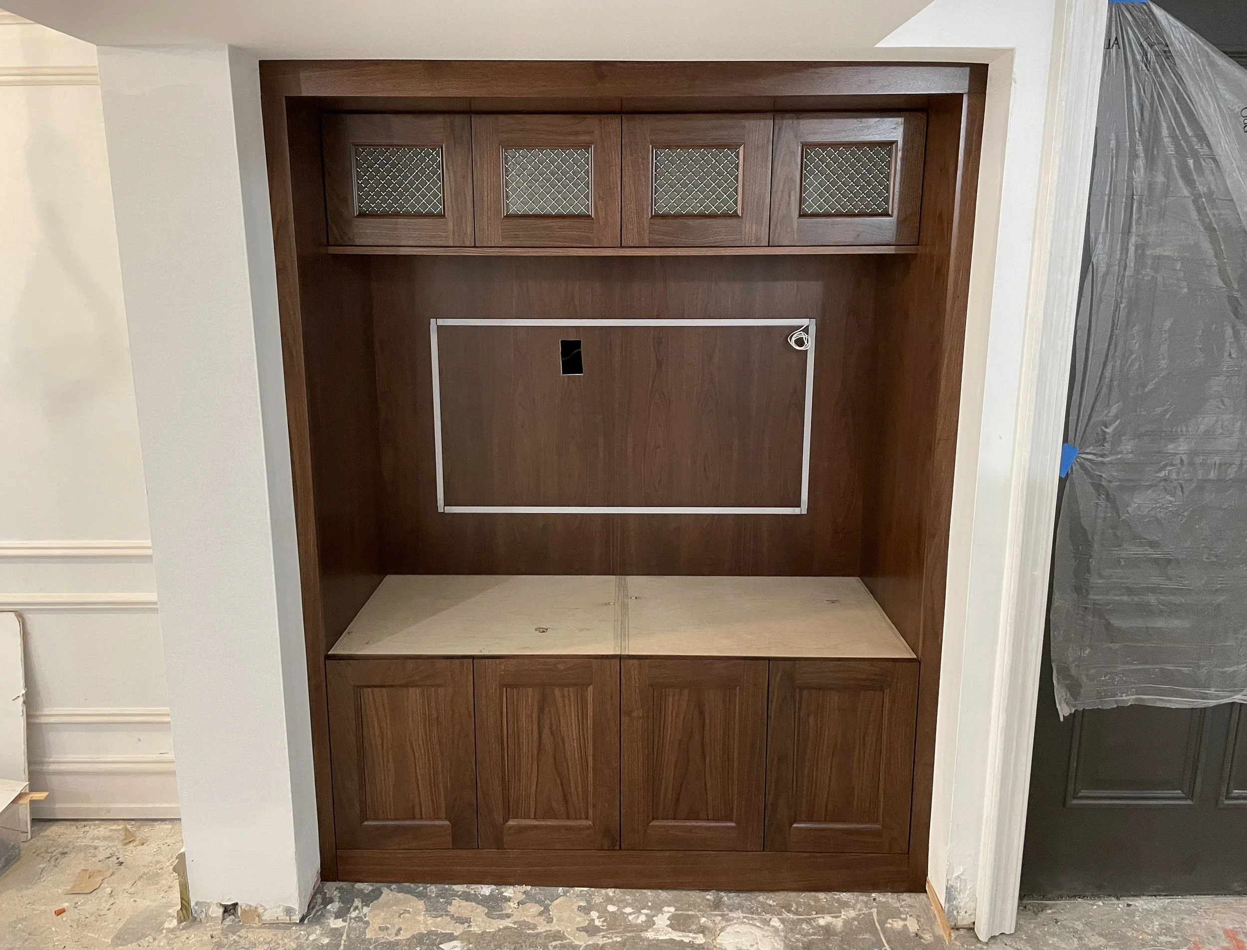 Custom dark wood TV wall with metal mesh