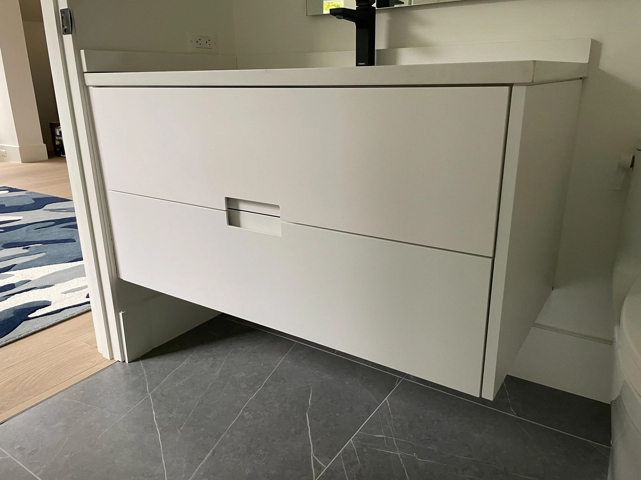 Custom white floating vanity with integrated pulls