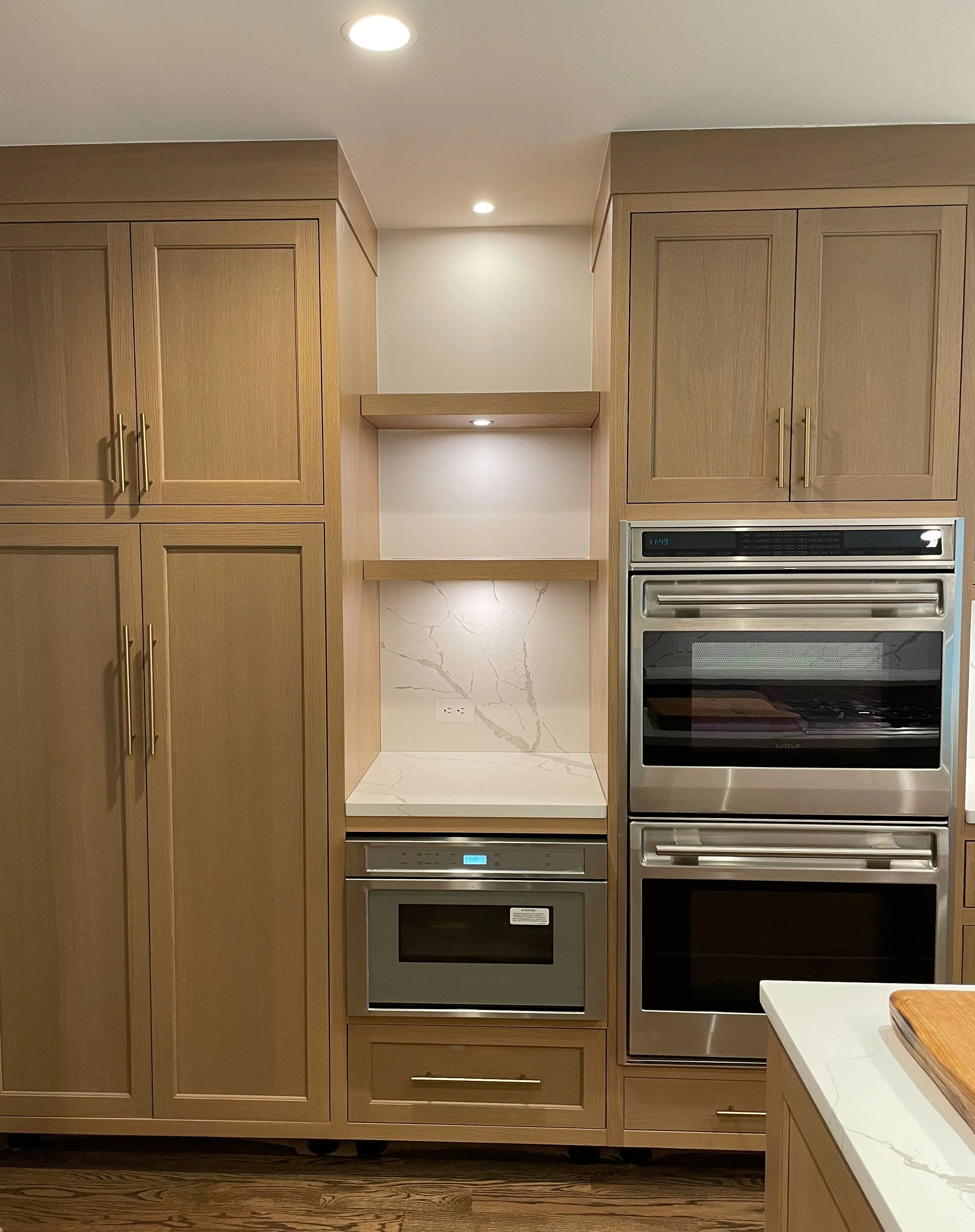 Inset white oak kitchen with quartz countertops and brass hardware 