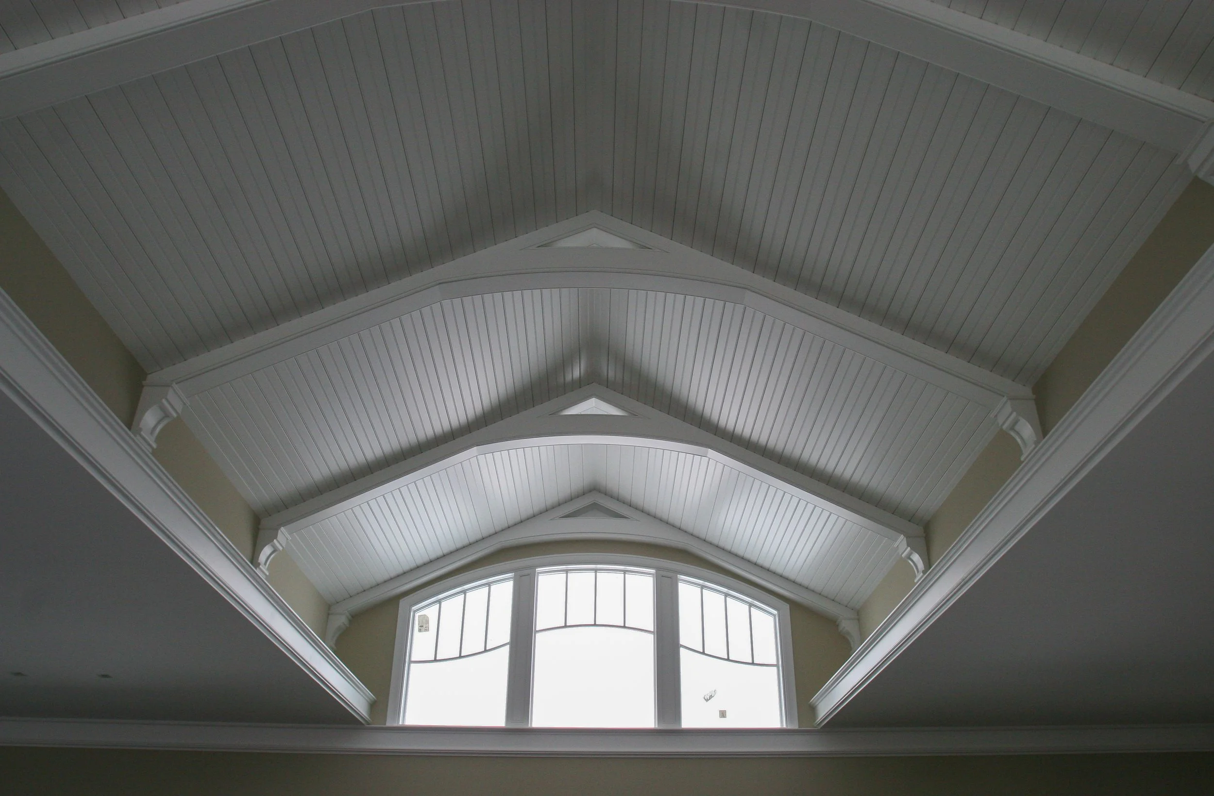 White vaulted ceiling with paneling and gable beams 