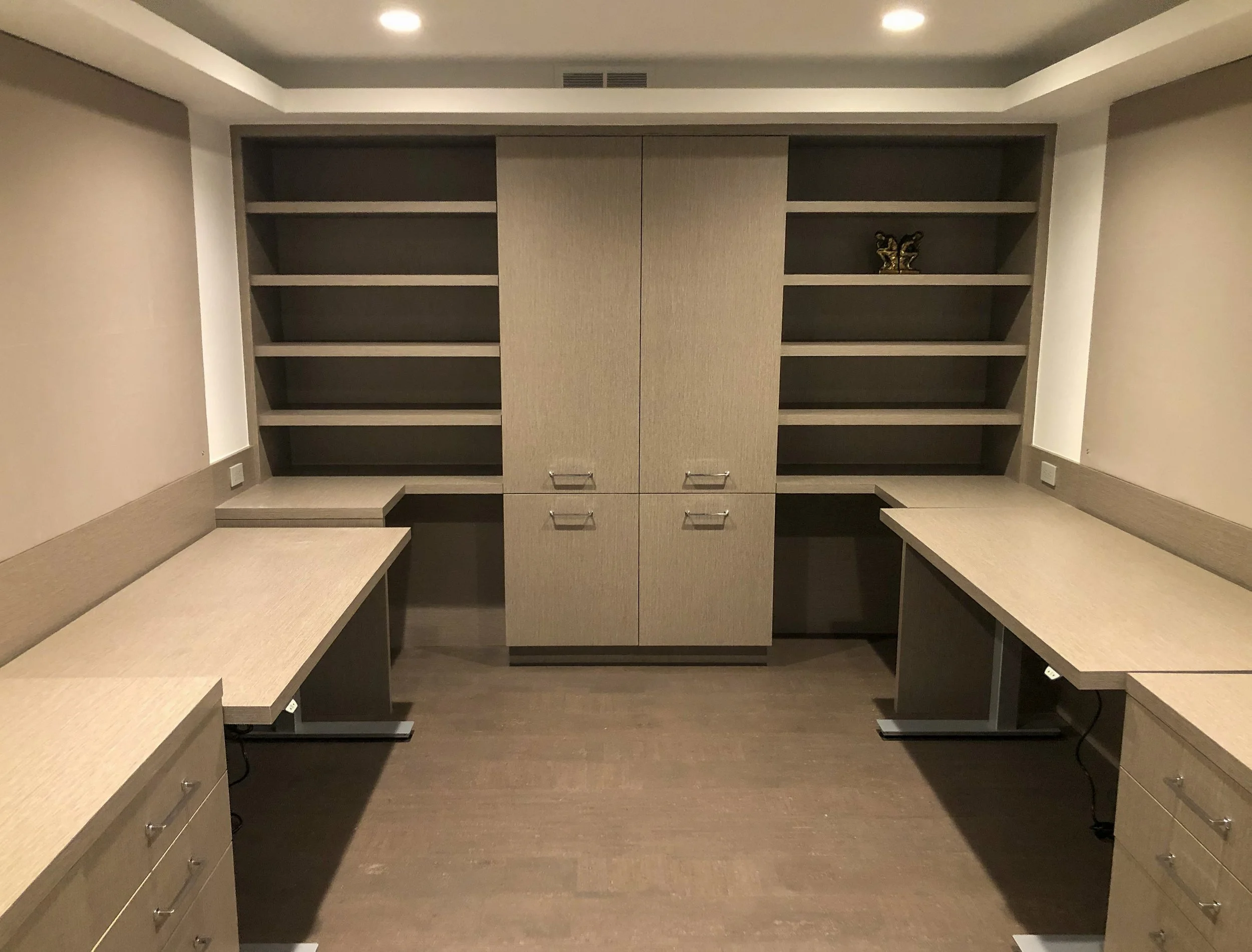 Modern home office with standing desks, closed storage, and open shelves in gray laminate.