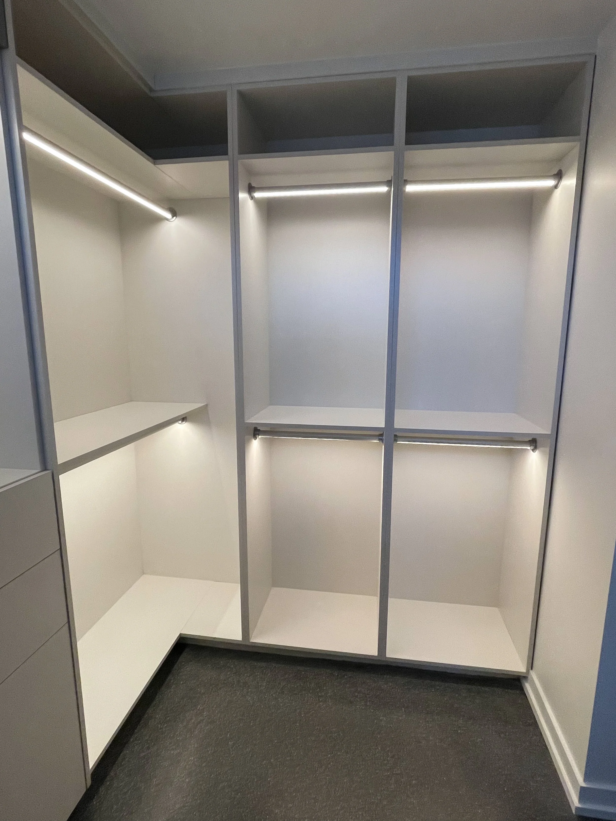 Modern white closet with lit rods and double hanging 