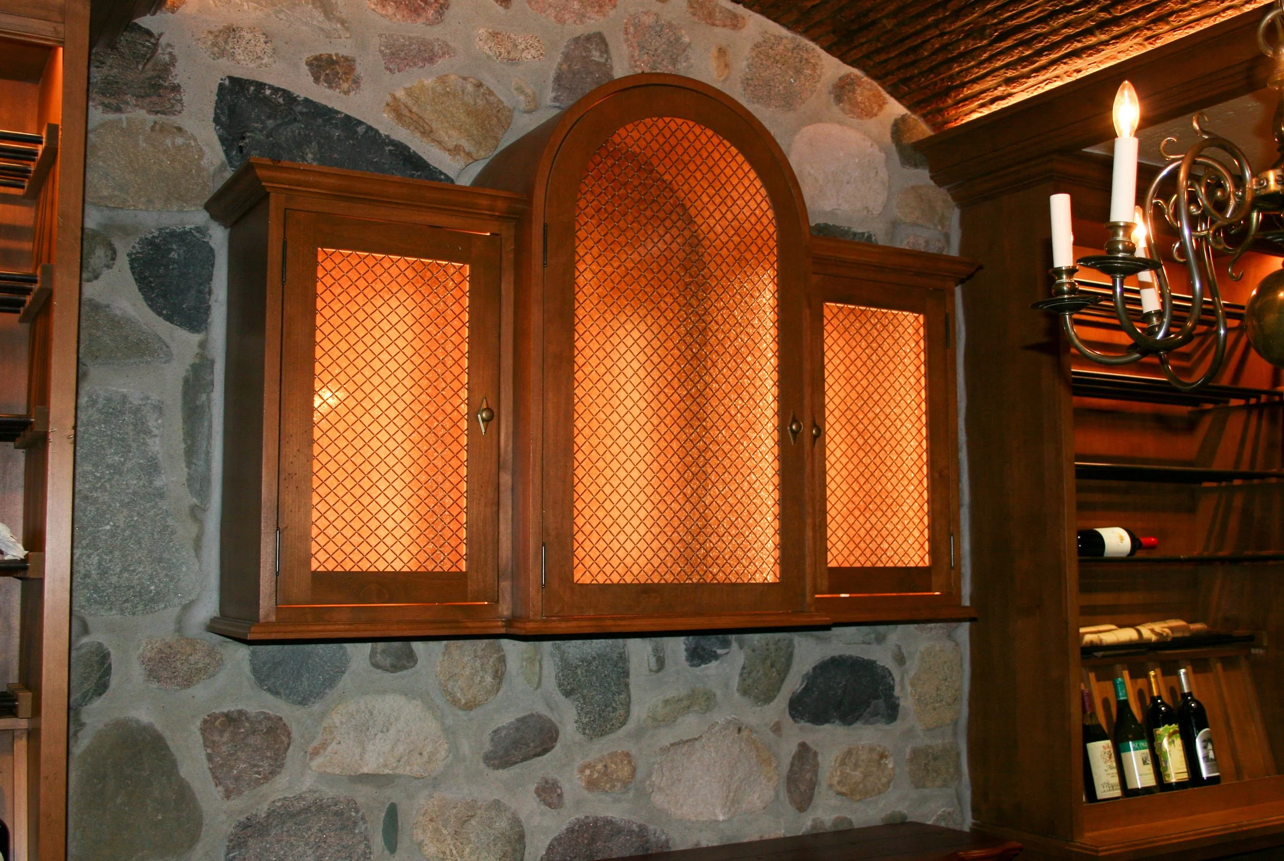 Arched cabinet with integrated lighting and mesh doors 