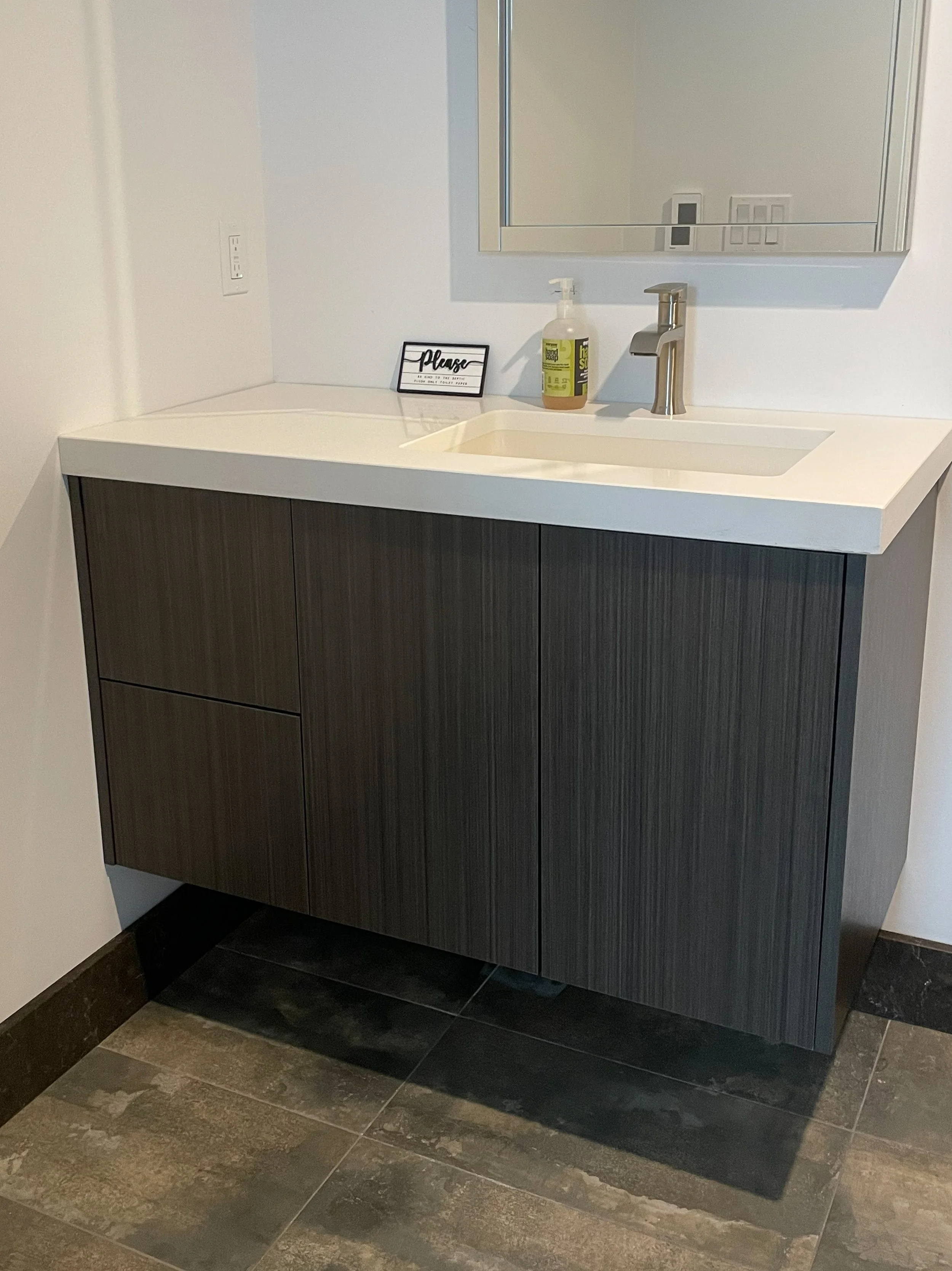 Custom floating laminate vanity with drawers on left and doors on right 
