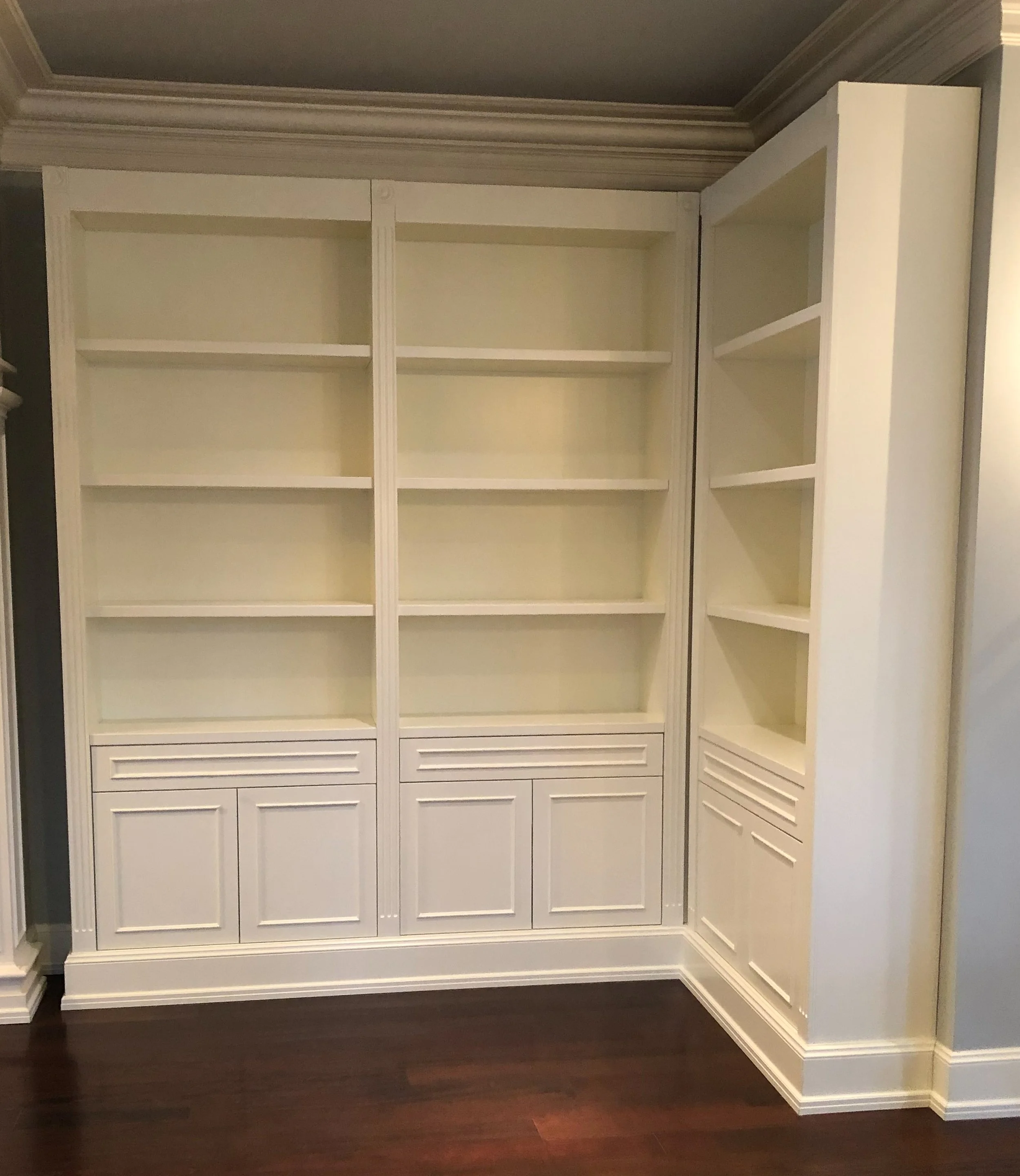 Custom white built-in with shelves above and doors and drawers below 