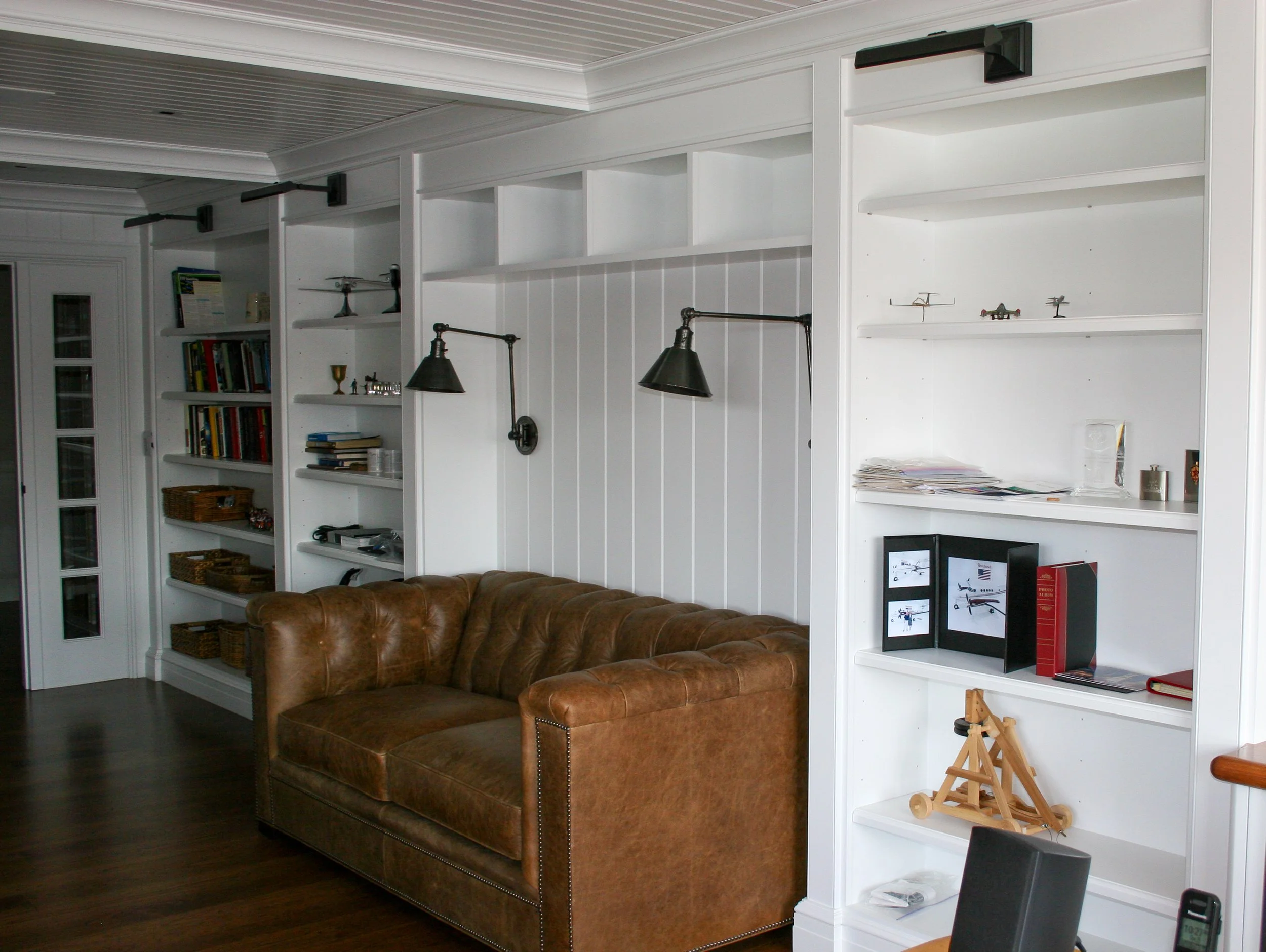 White home office with tufted leather sofa