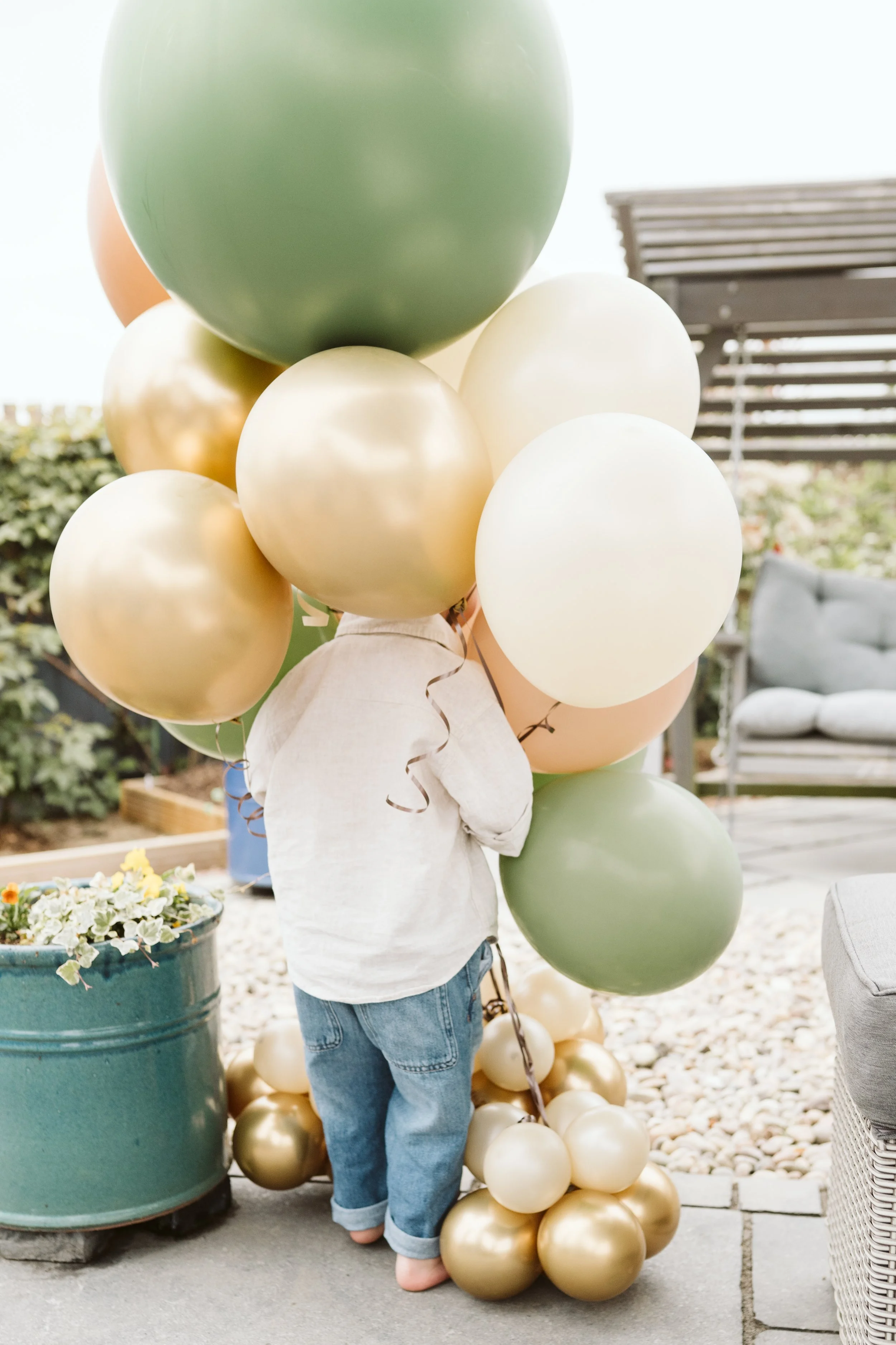 Cluster of neutral and green balloons at a children’s party
