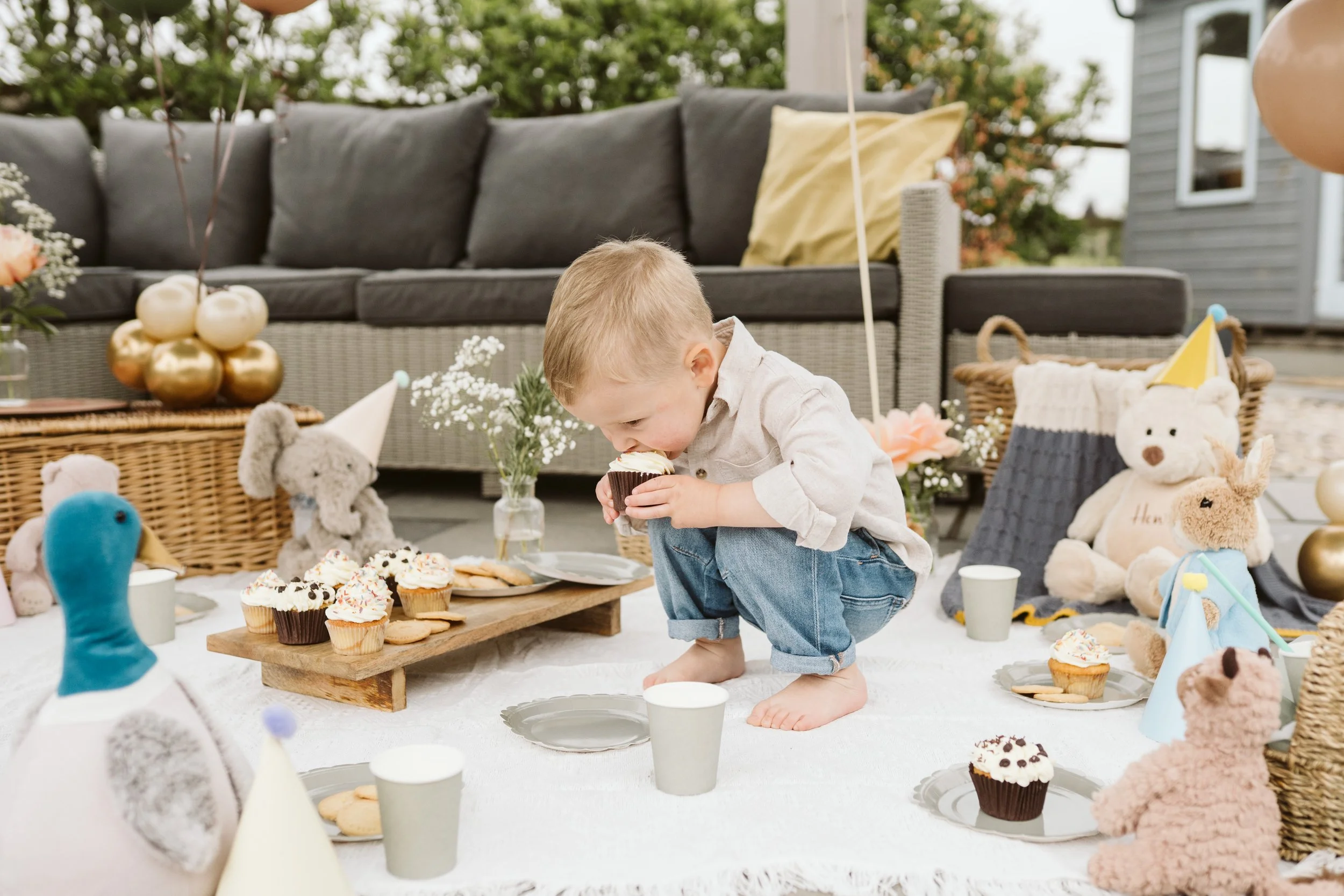 Child enjoying an outdoor party table with balloons and decorations