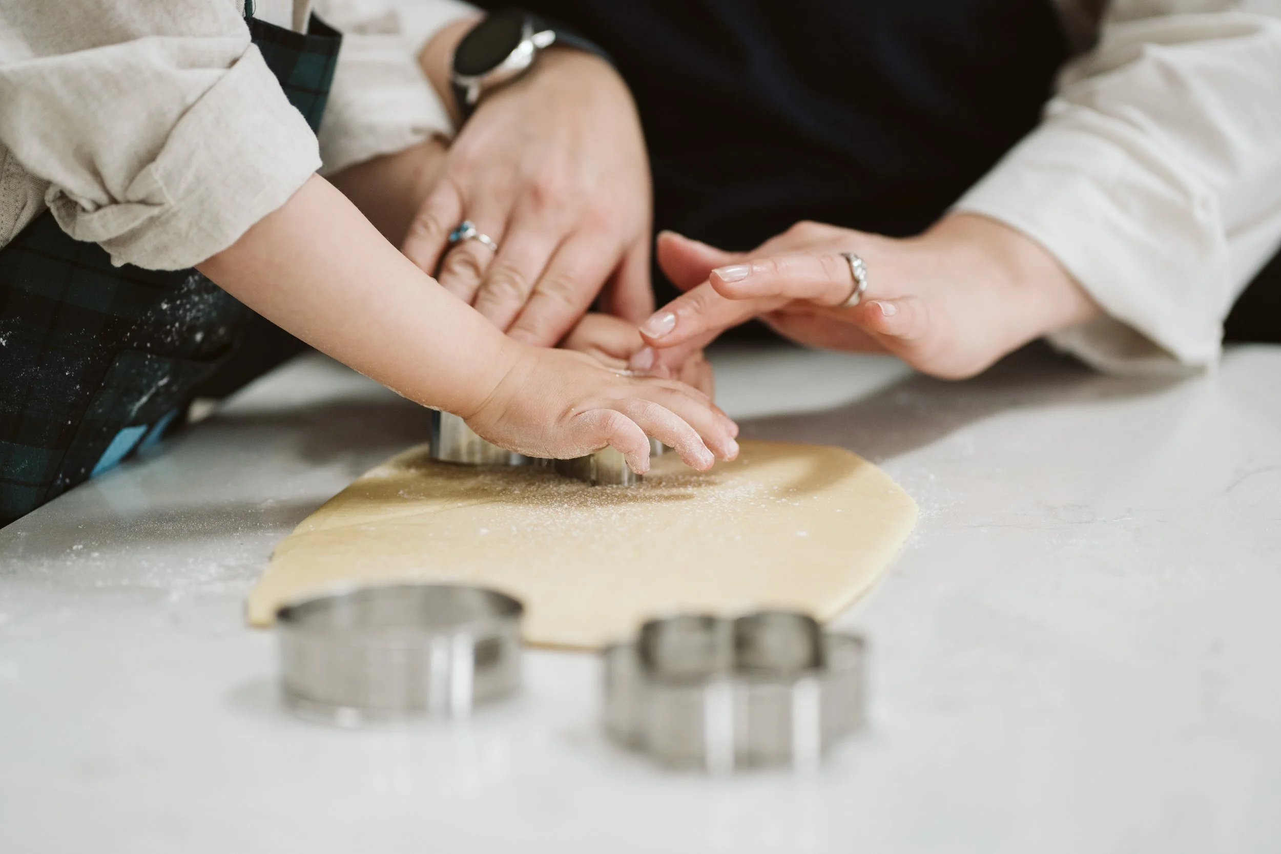 Parent and child cutting shapes from cookie dough.