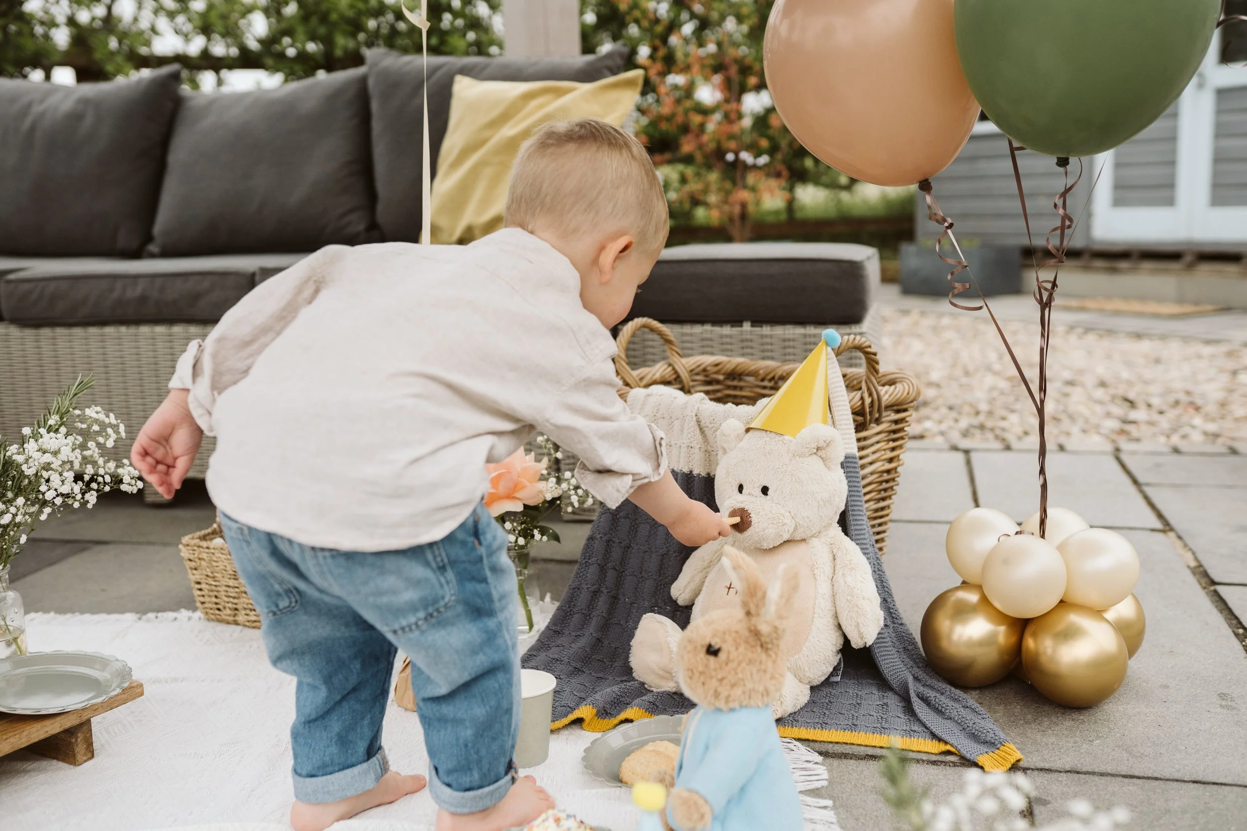 Mum helping child at a decorated outdoor party table
