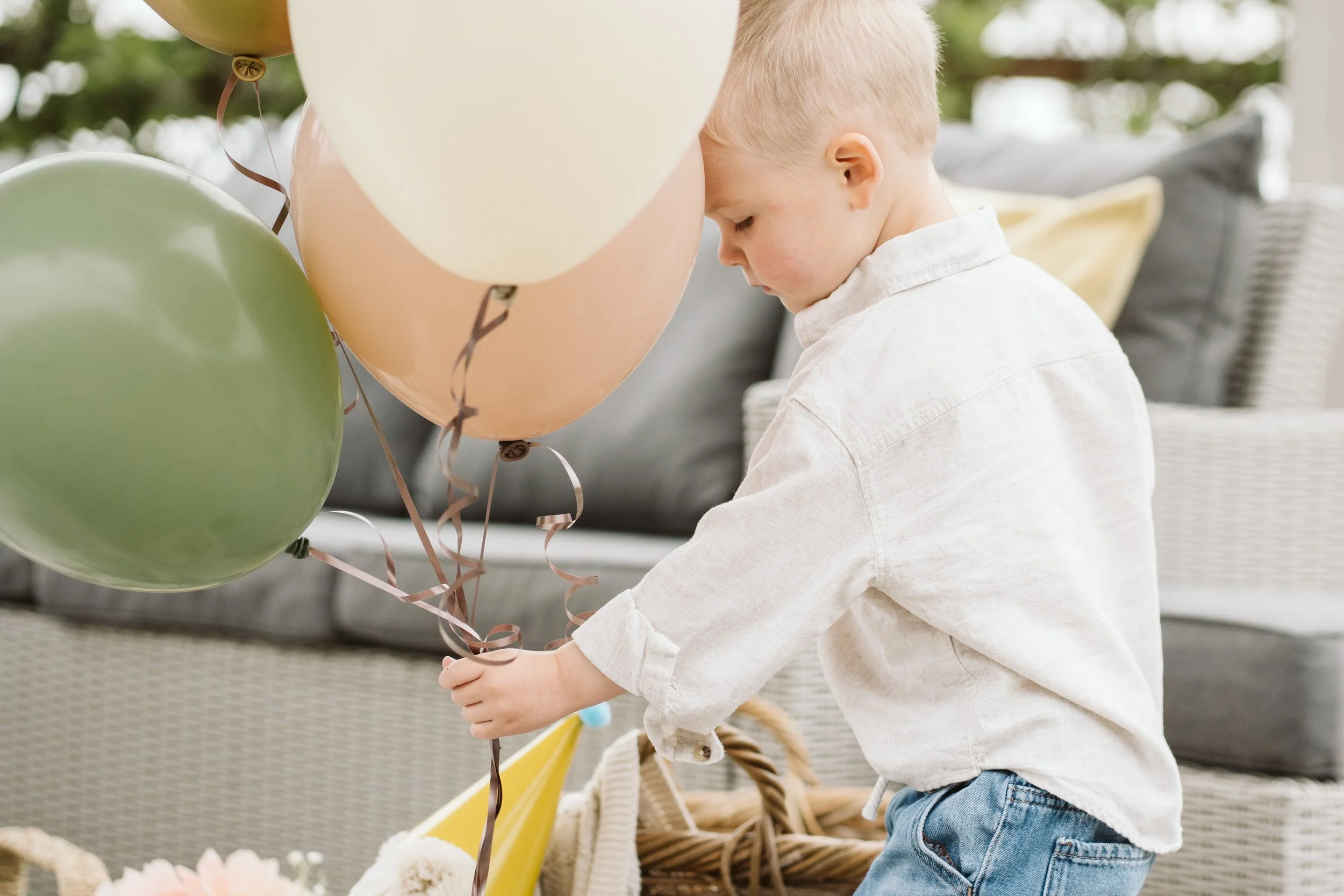 Child playing with balloons at a decorated party table