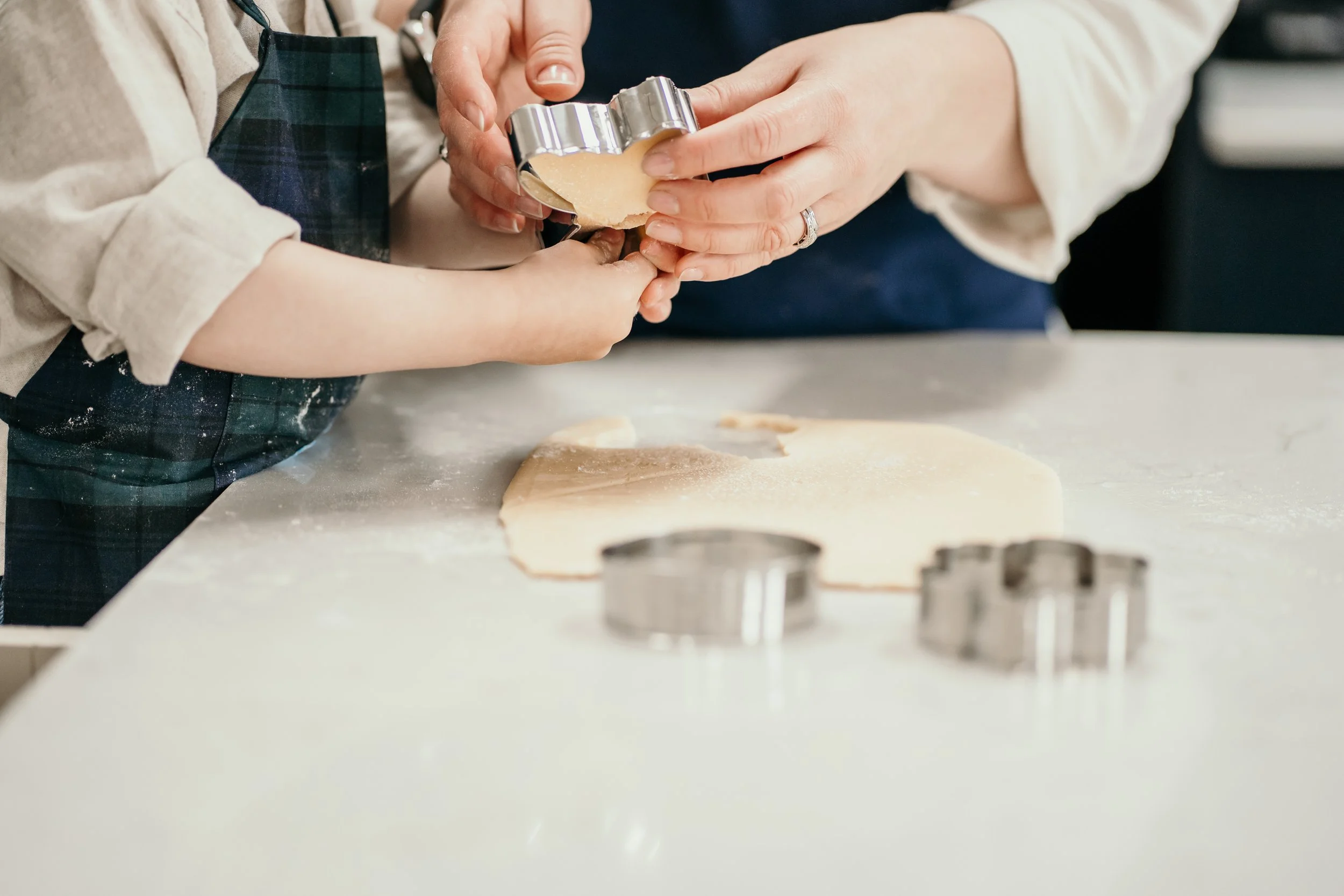Child decorating freshly rolled cookie dough.