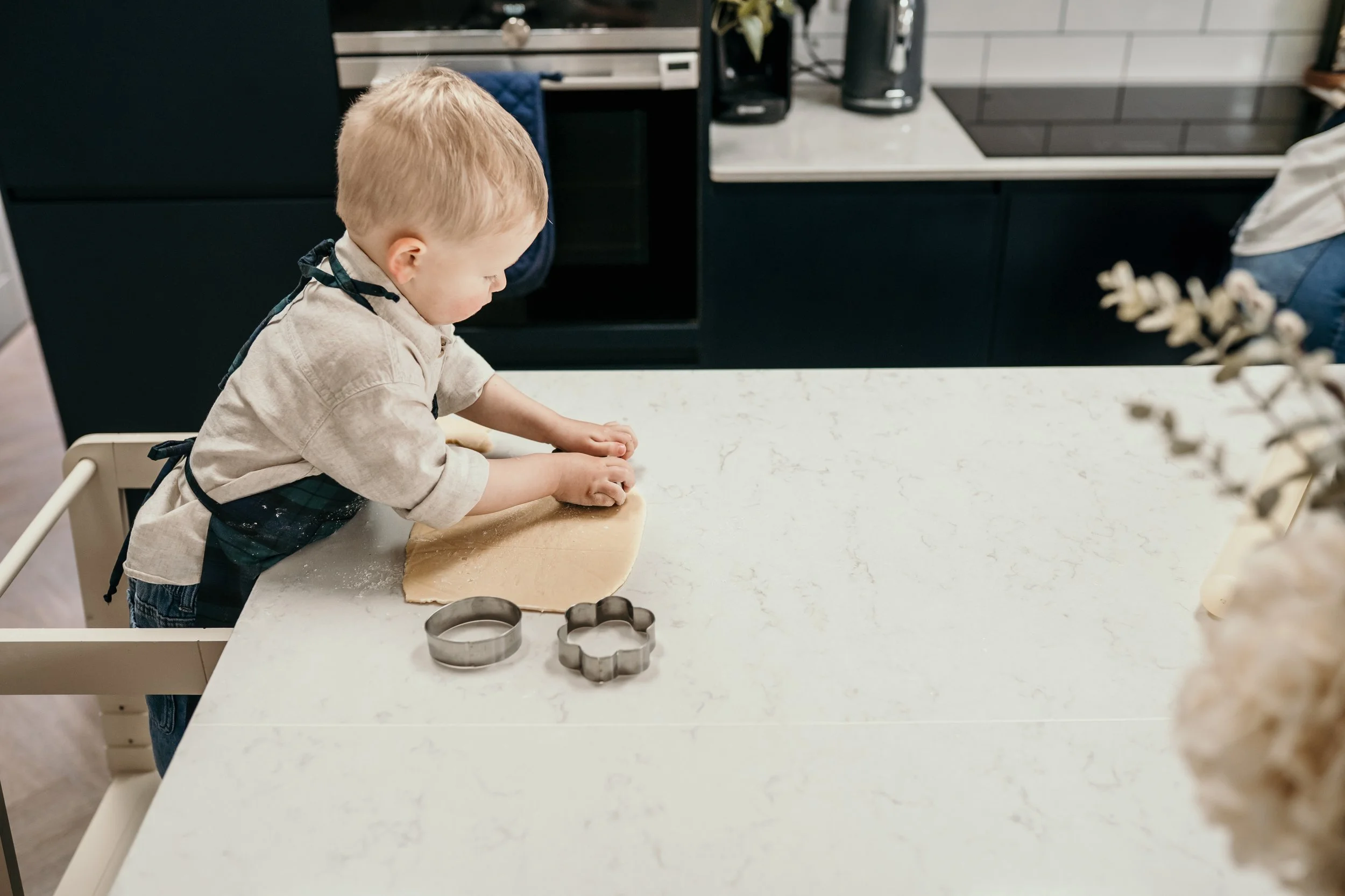 Child cutting cookie dough with a cookie cutter.