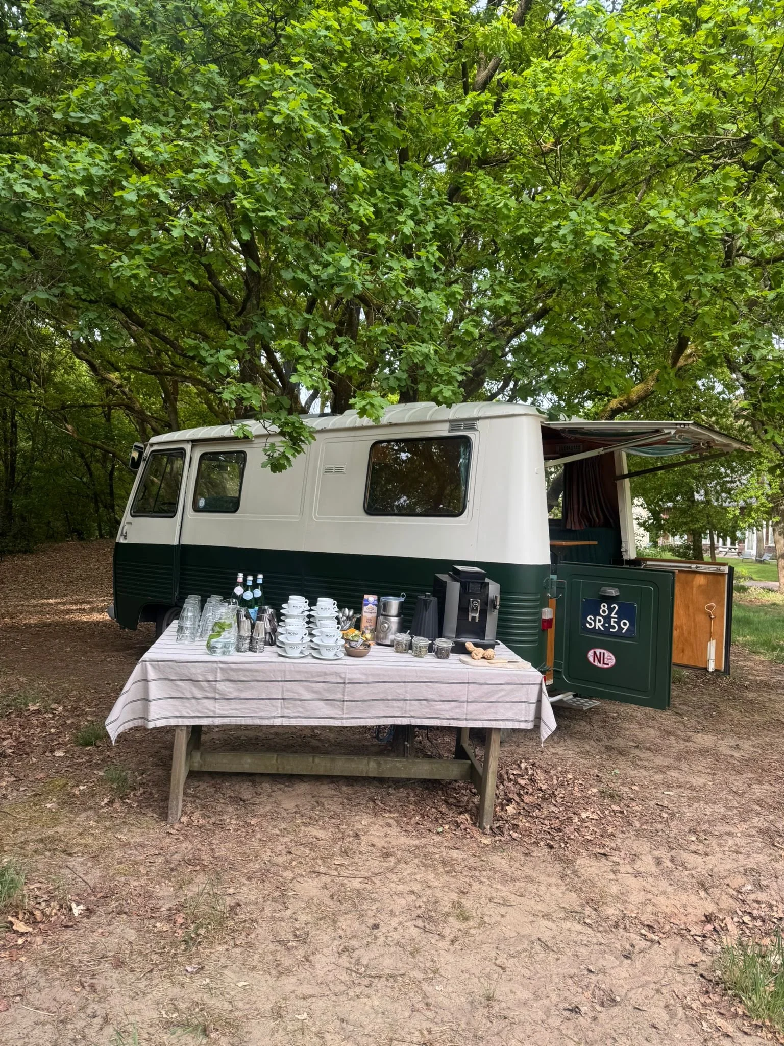 Een tafel met ontbijtproducten, waaronder plakjes kaas, vleeswaren, brood met smeersel, yoghurt, granola en granola met veel verschillende toppings. Elk soort heeft een label met de naam.