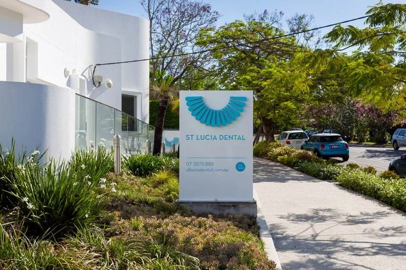 A construction site with a large excavator demolishing a building, rubble and debris scattered around, two construction workers in safety vests and helmets monitoring the work.