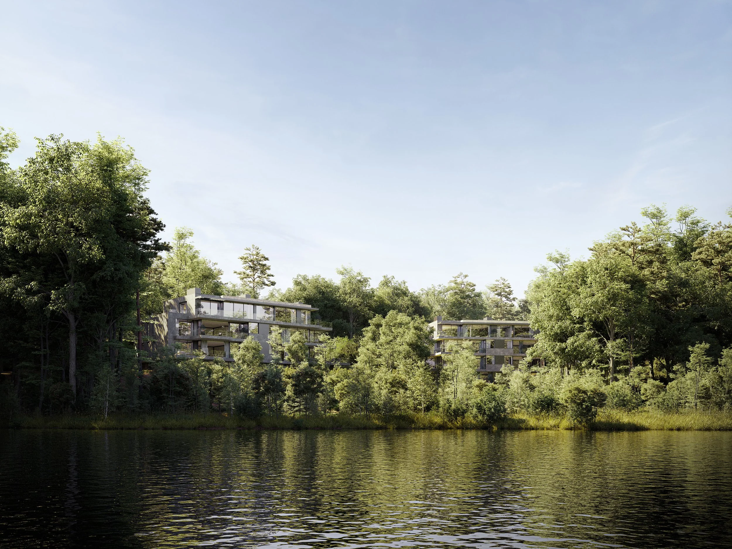 Modern apartment buildings on a wooded hillside across a body of water, with a clear sky above.